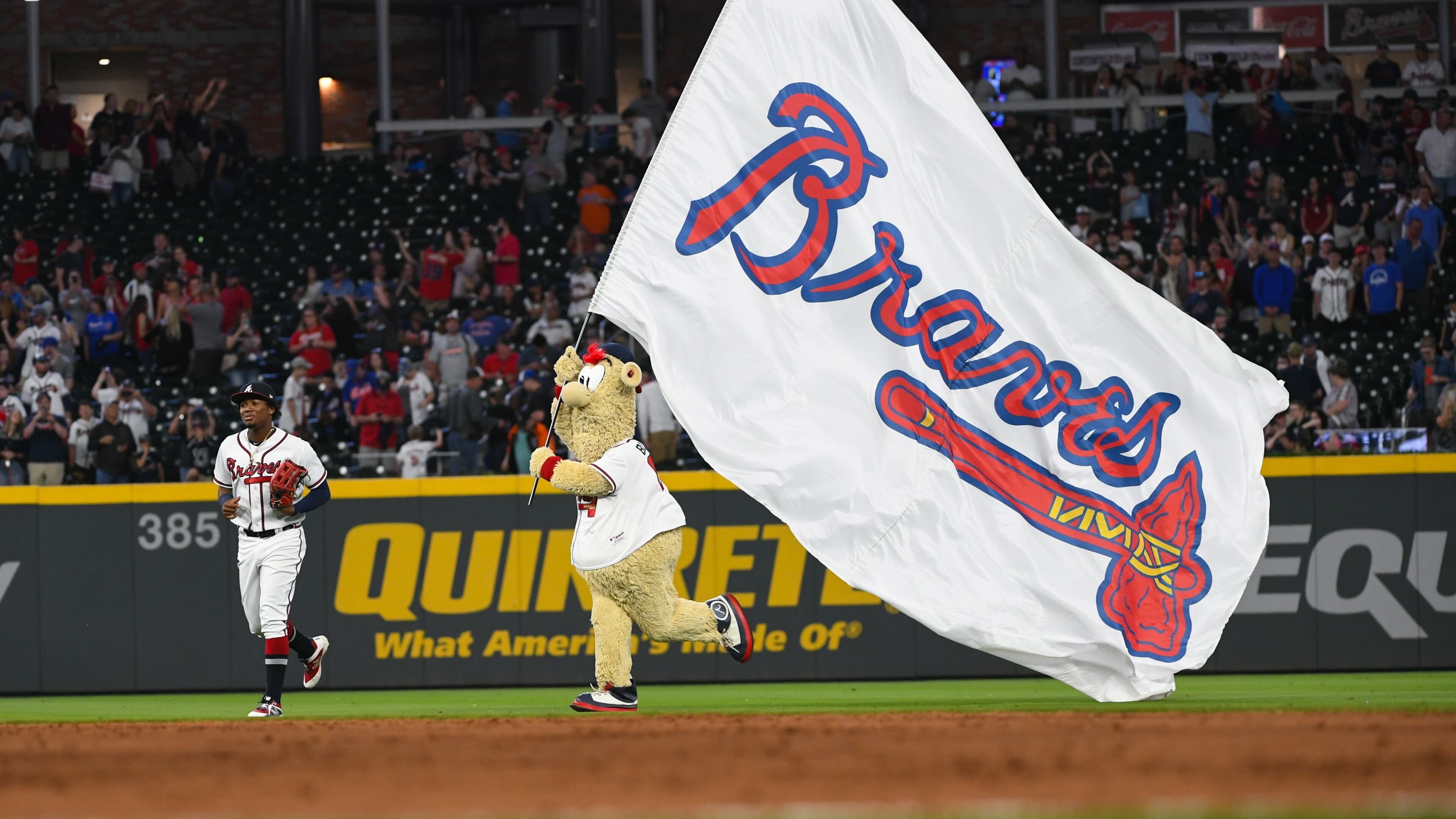 Ronald Acuna Jr. #13 of the Atlanta Braves is followed by Blooper the team mascot after an 11-7 win over the New York Mets at SunTrust Park on April 13, 2019 in Atlanta, Georgia. The Braves won 11-7. (Photo by John Amis/Getty Images)