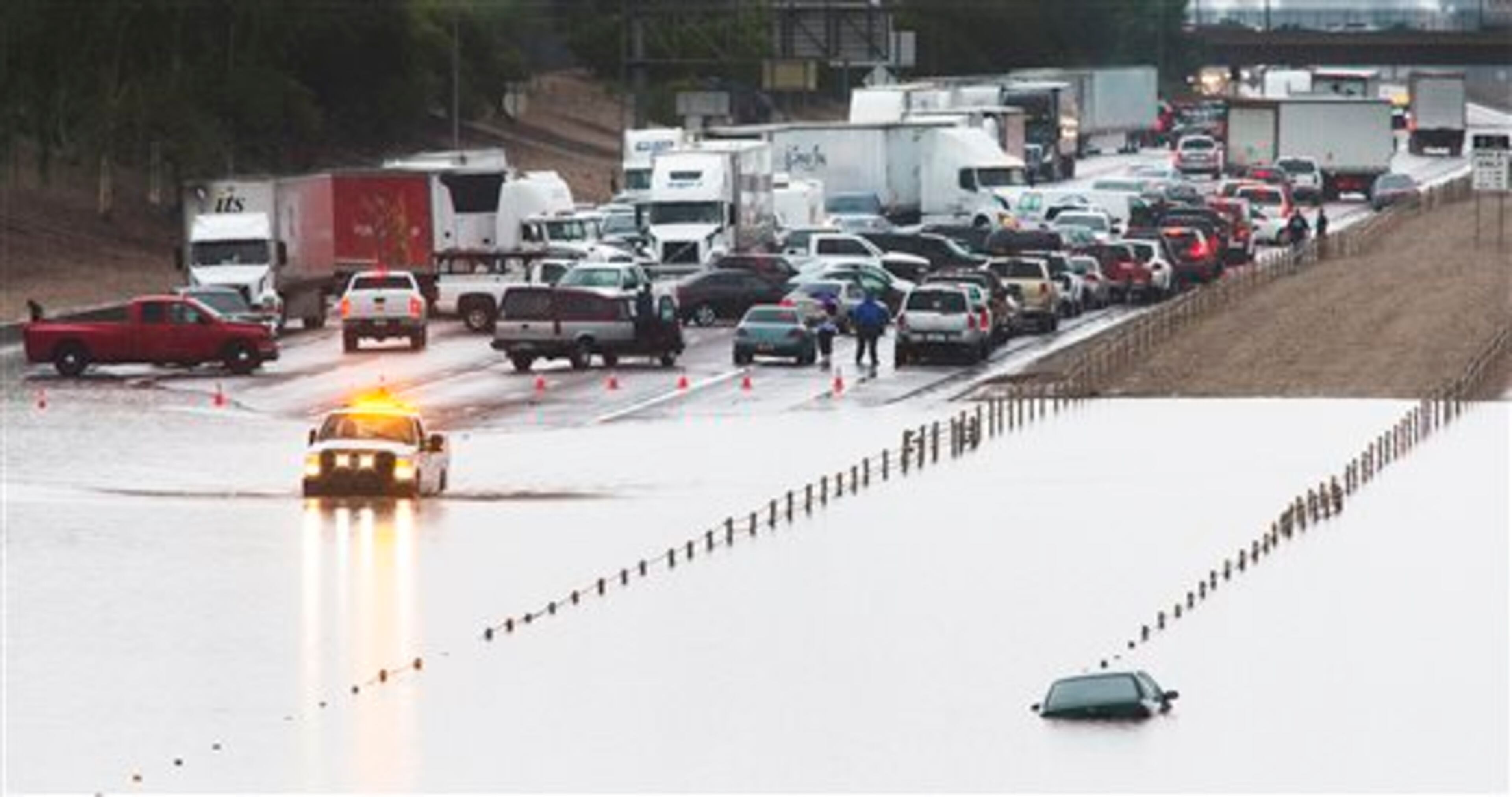 Traffic is stopped in the eastbound lanes of I-10 and cars are underwater at 43rd Ave. and I-10 in the westbound lanes in Phoenix, Monday, Sept. 8, 2014 after record-setting rainfall caused massive flooding throughout the Valley. More than 20 cars were stranded when fast rising water flooded the underpass. (AP Photo/The Arizona Republic, Tom Tingle) ***MARICOPA COUNTY OUT - NO MAGS- NO SALES - MANDATORY CREDIT***
