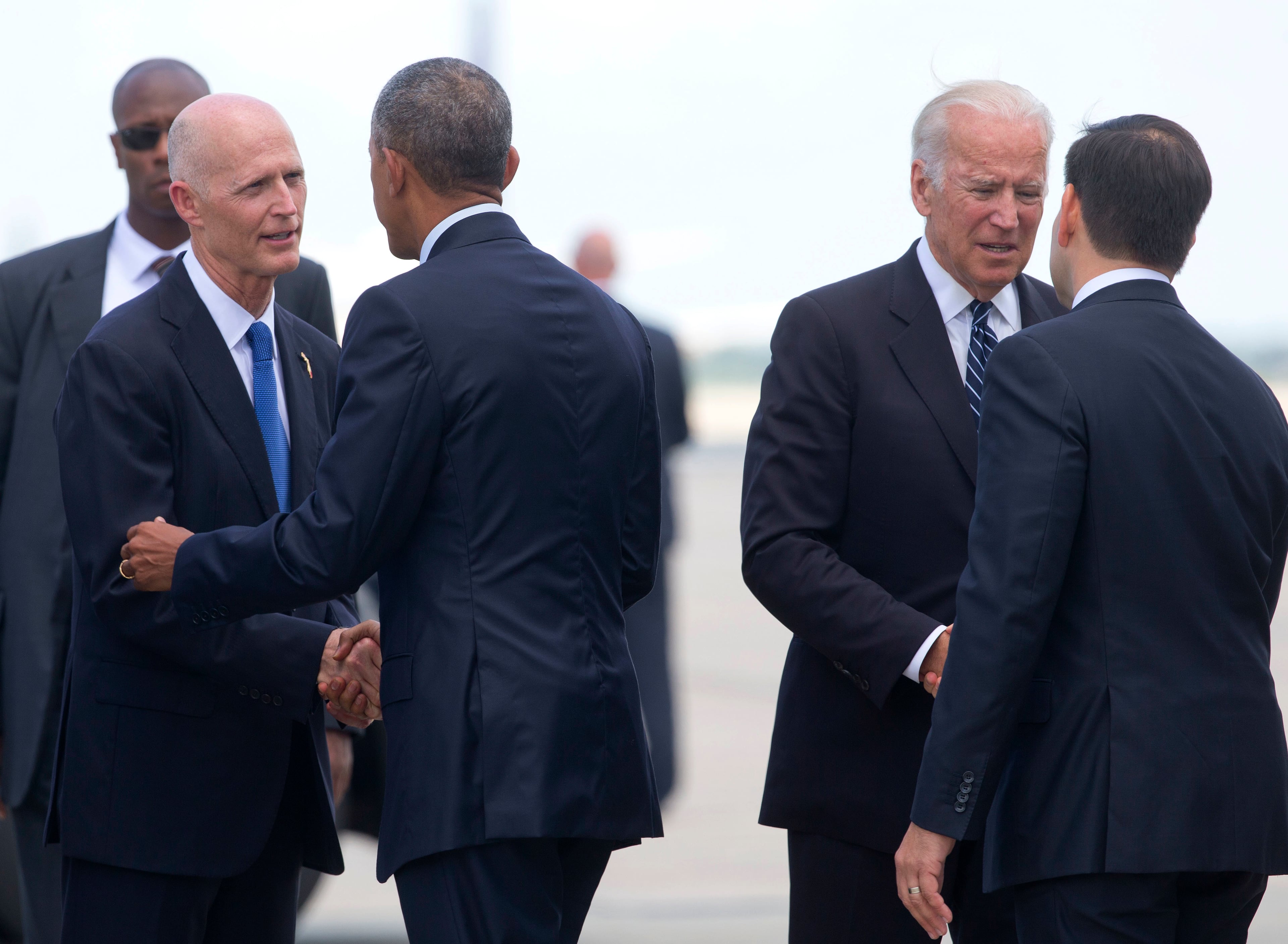 President Barack Obama is greeted by Florida Gov. Rick Scott, left, as Vice President Joe Biden greets Sen. Marco Rubio, R-Fla., right, on the tarmac at Orlando International Airport, Thursday, June 16, 2016, in Orlando, Fla. Both President Obama and Vice President Joe Biden are in Orlando today to pay respects to the victims of the Pulse nightclub shooting and meet with families of victims of the attack. (AP Photo/Pablo Martinez Monsivais)