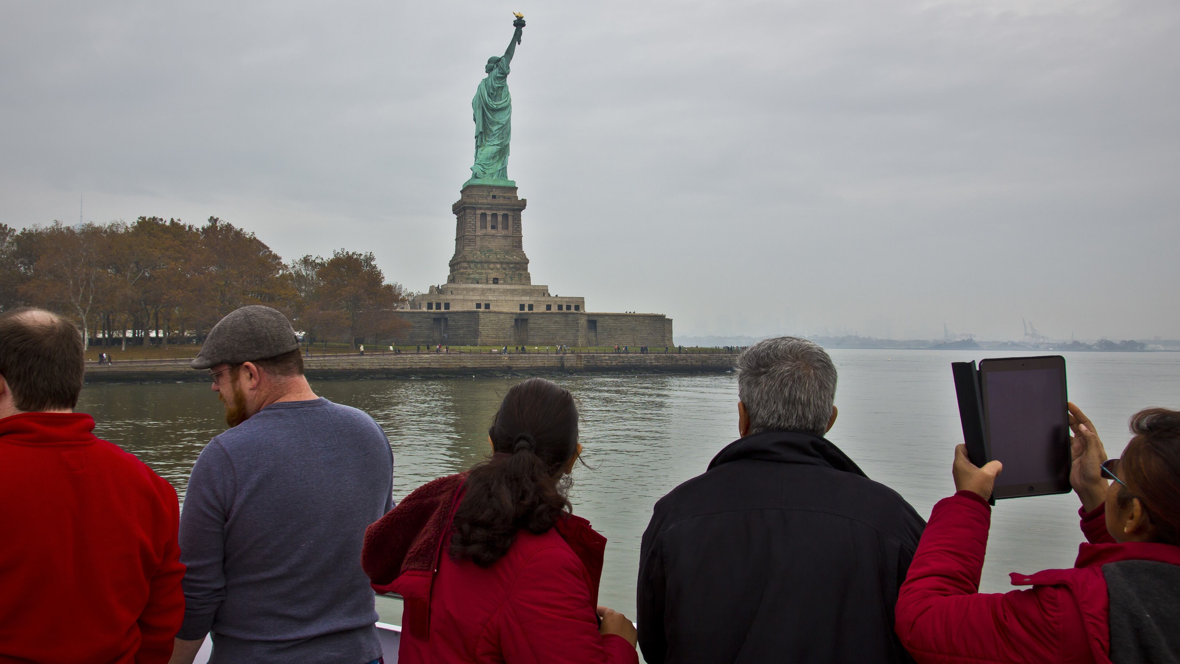 In this Nov. 5, 2015, file photo, visitors view the Statue of Liberty during a ferry ride to Liberty Island in New York. The U.S. Travel Association on Thursday, March 2, 2017, said there are "mounting signs" that the Trump administration's policies are having a "broad chilling effect on demand for international travel to the United States." (AP Photo/Bebeto Matthews, File)