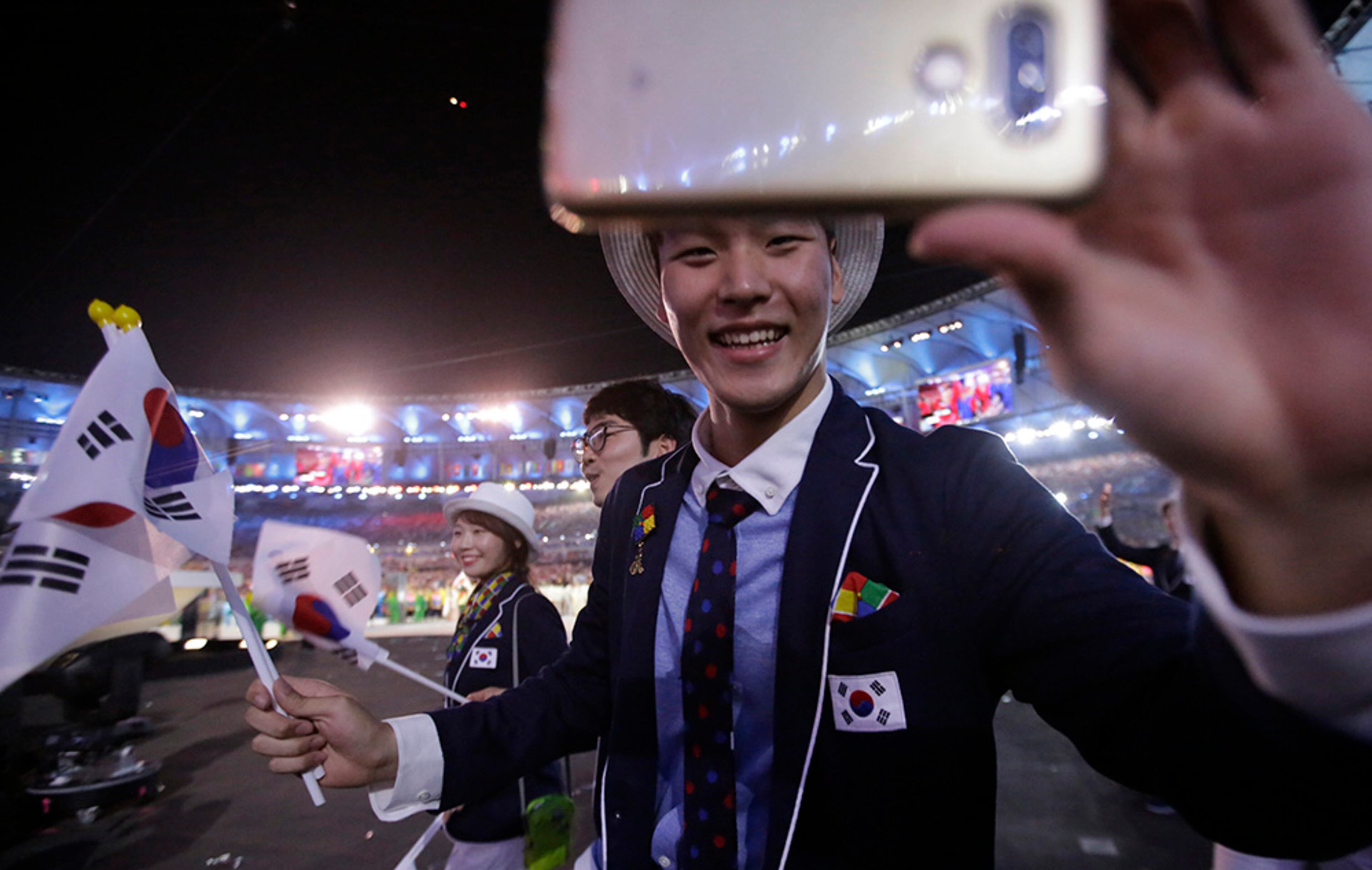 A member of the South Korean team holds up his phone as he marches in the arena during the opening ceremony for the 2016 Summer Olympics in Rio de Janeiro, Brazil, Friday, Aug. 5, 2016.