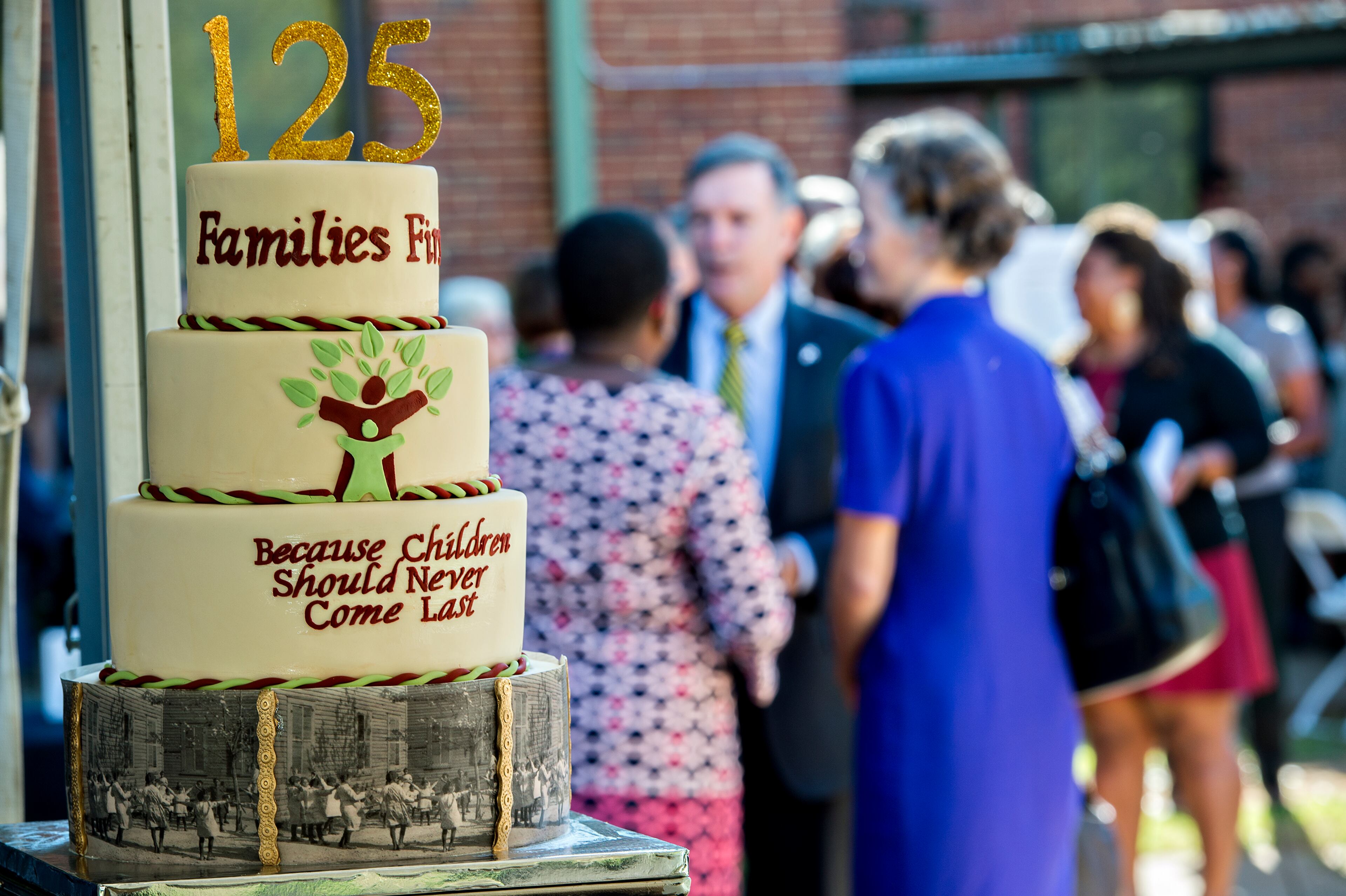 Supporters congregate near the cake celebrating the 125 years of service for the Families First organization before the start of the groundbreaking ceremony at the historic E.R. Carter Elementary School in Atlanta on Thursday, September 17, 2015. The school will become the new site of the Families First Resource Center. Families First is celebrating 125 years of helping Georgia families become self sufficient in a safe, stable and nurturing environement. JONATHAN PHILLIPS / SPECIAL