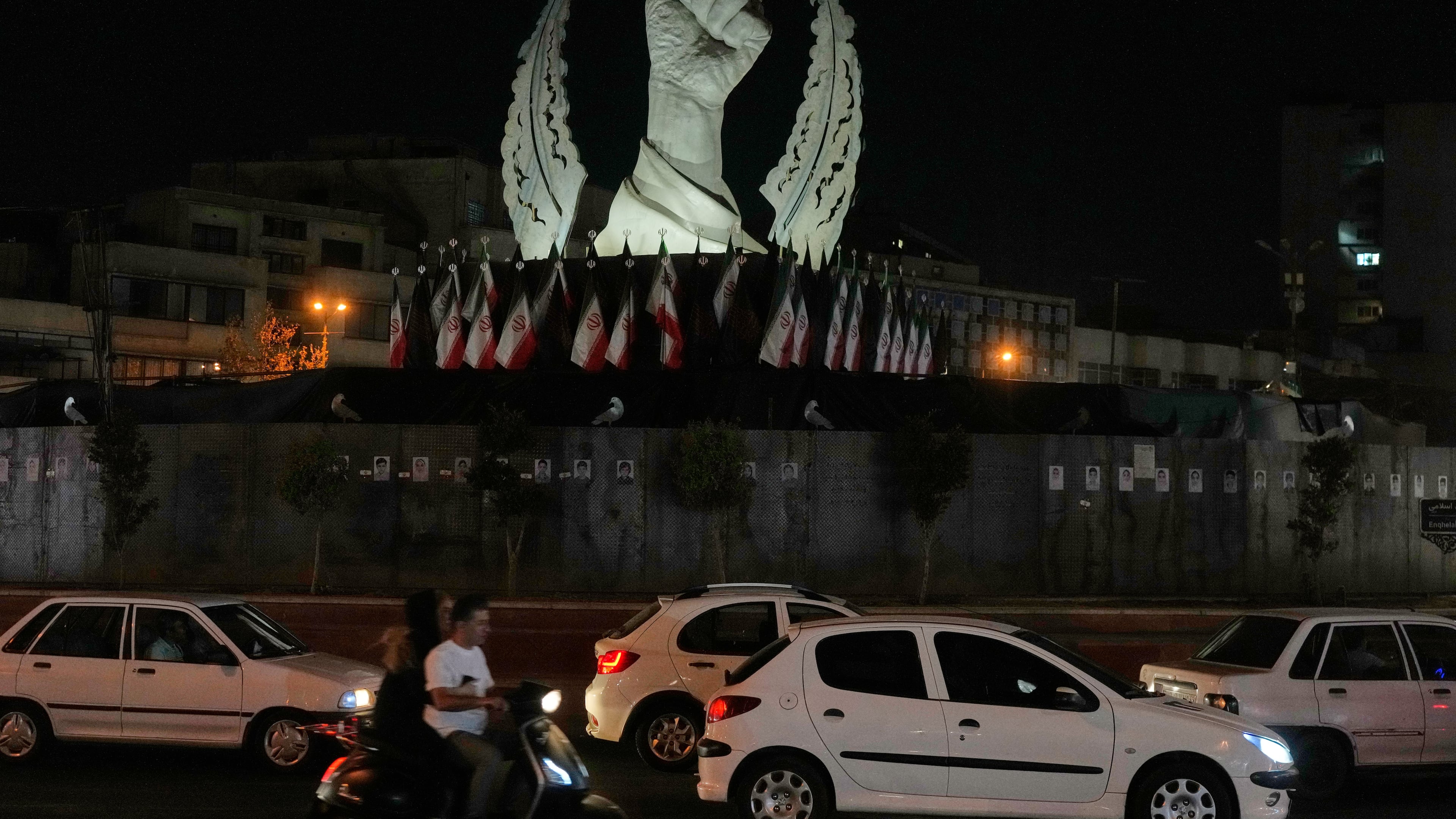 Vehicles drive past a monument depicting the clenched fist of the late Iranian Supreme Leader Ayatollah Ali Khamenei, who was killed in the U.S. and Israel strike on Feb. 28, in Islamic Revolution Square in Tehran, Sunday, July 19, 2026. (AP Photo/Vahid Salemi)