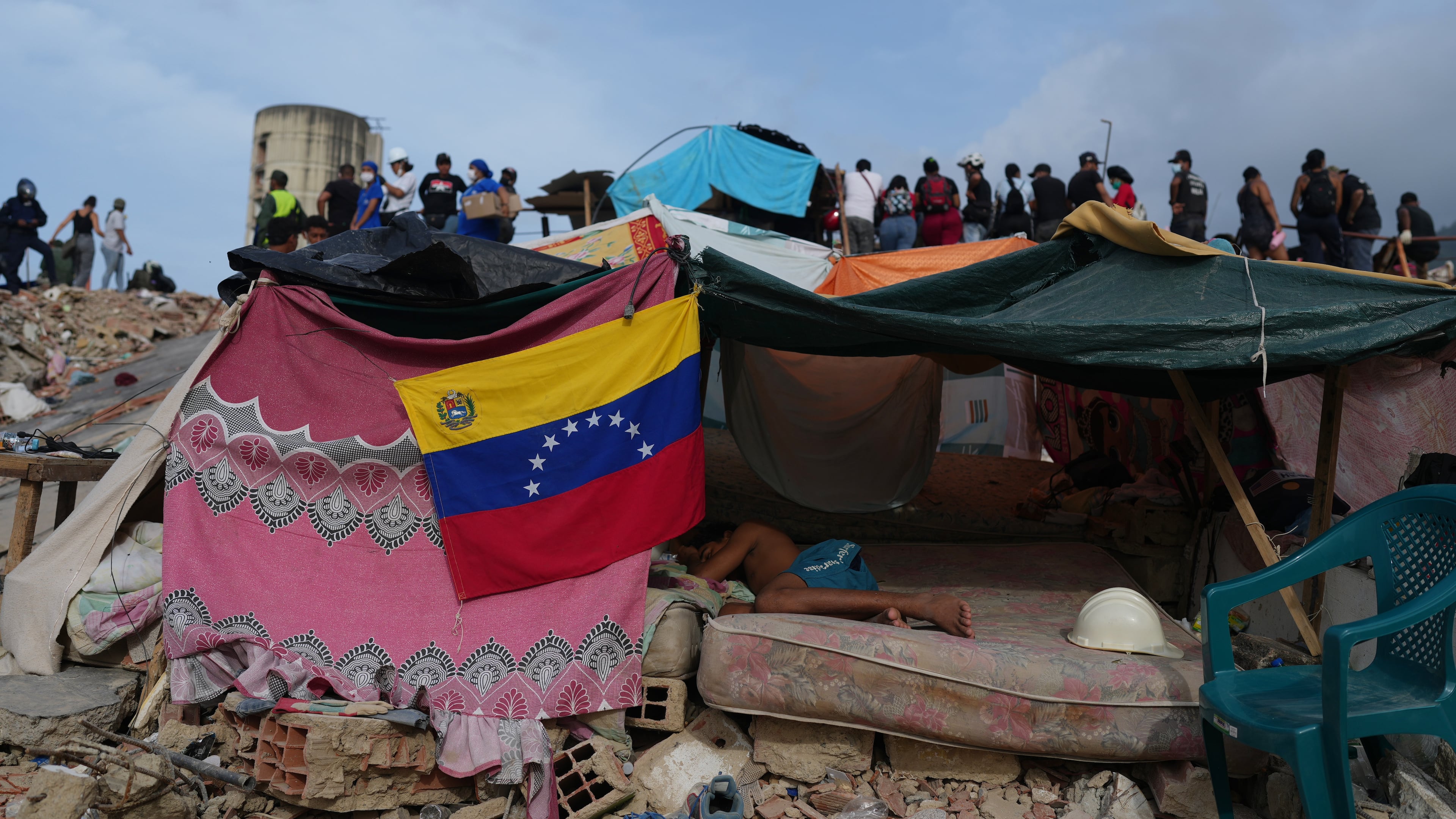 A young man sleeps as rescue workers continue searching through the rubble after the earthquakes in La Guaira, Venezuela, Saturday, July 4, 2026. (AP Photo/Ariana Cubillos)