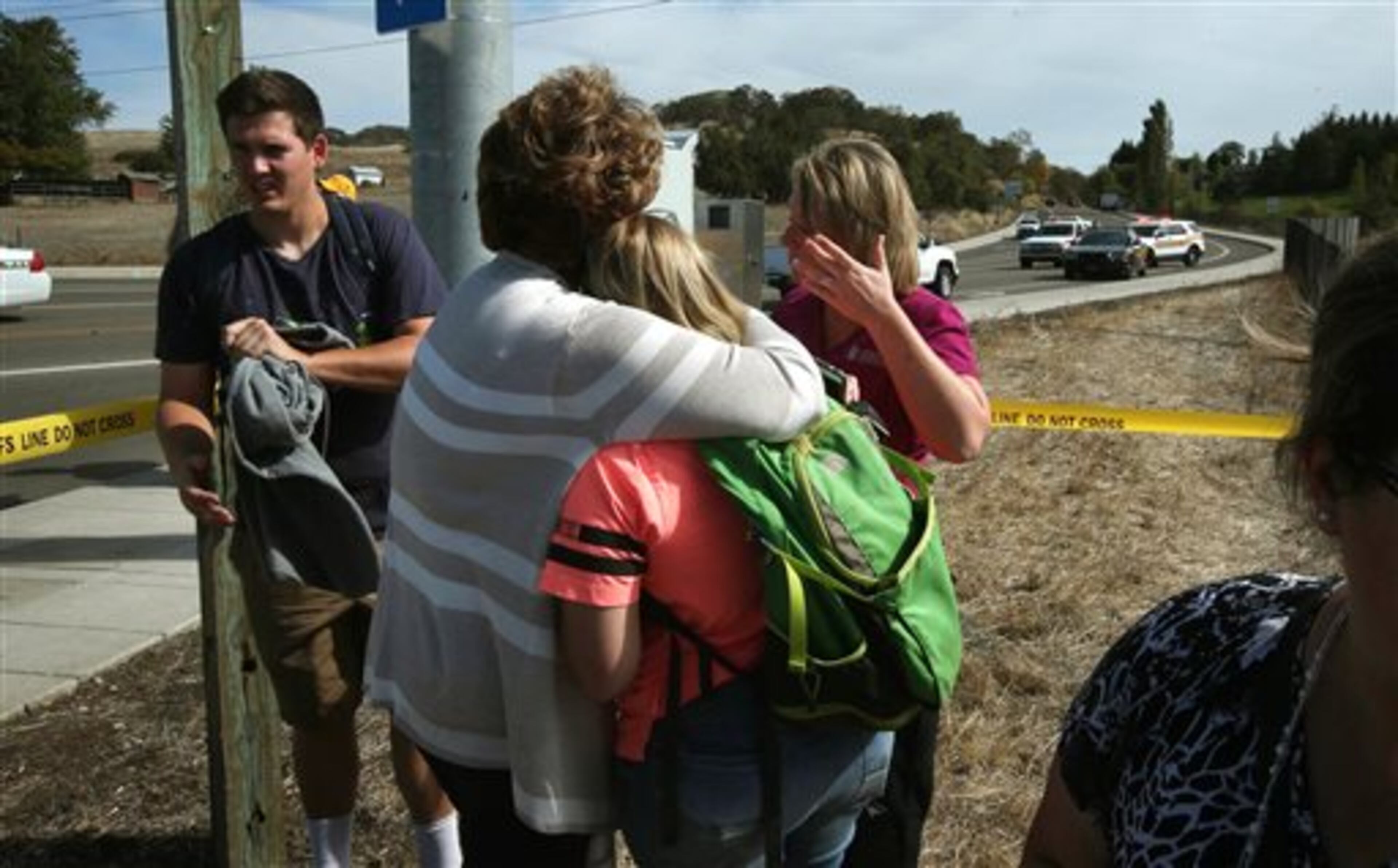 Click on this link for updates on the Oregon school shooting. Bystanders console each other on a road leading to the Umpqua Community College campus in Roseburg, Ore. Thursday, Oct. 1, 2015, following a deadly shooting at the school. (Chris Pietsch /The Register-Guard via AP) MANDATORY CREDIT