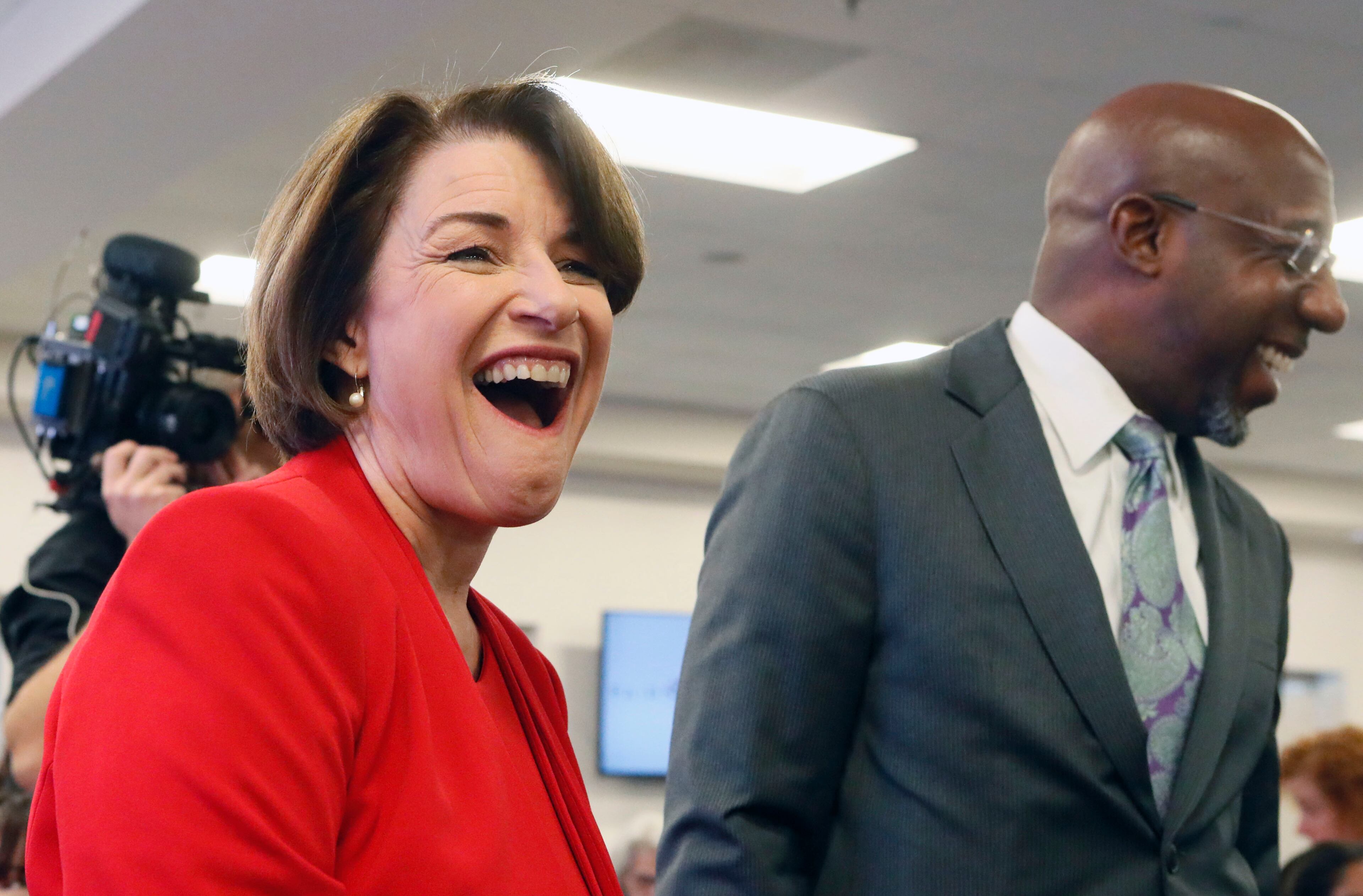November 21, 2019 - Atlanta - Amy Klobuchar shares a laugh with Ebenezer Baptist Church pastor Rev. Raphael G. Warnock. Democratic presidential candidates including Cory Booker, Amy Klobuchar, Andrew Yang and Pete Buttigieg, along with Stacey Abrahms, were calling and texting voters Thursday whose registrations could be canceled in Georgia at a Fair Fight phone bank at Ebenezer Baptist Church in Atlanta. The phone bank was in response to Georgia election officials' plan to cancel more than 313,000 voter registrations next month. Bob Andres / robert.andres@ajc.com