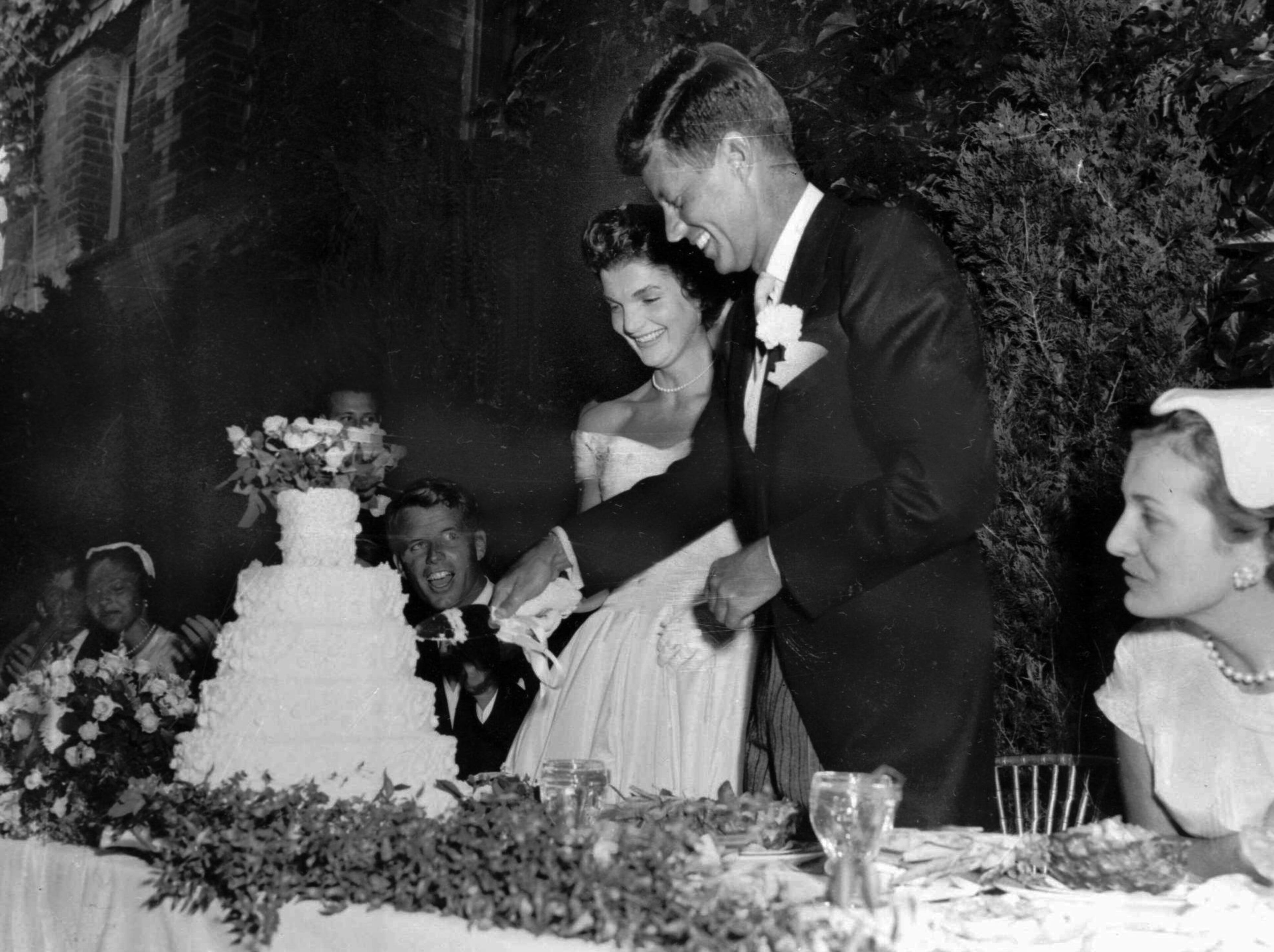 U.S. Sen. John F. Kennedy, D-Mass., and his bride, the former Jacqueline Lee Bouvier, cut their wedding cake during a reception following their marriage at Newport, R.I. (AP Photo)
