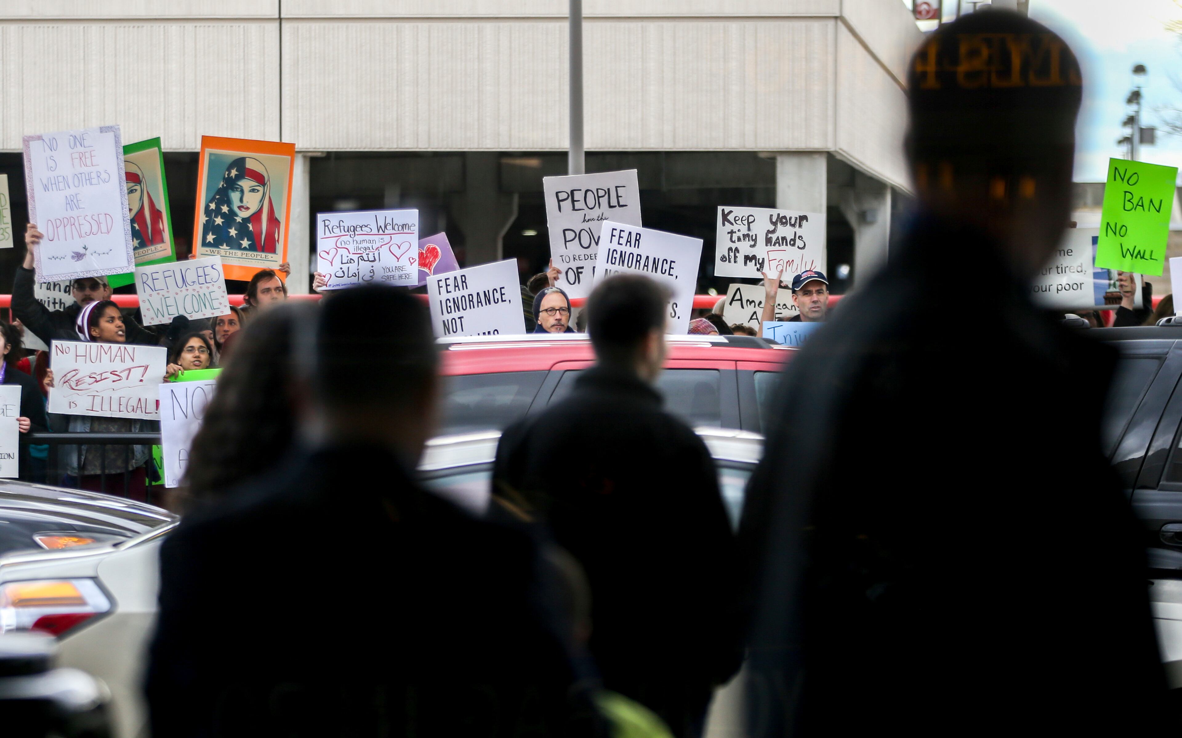 Passengers watch protesters at Hartsfield-Jackson International Airport during a demonstration to denounce President Donald Trump's executive order that bars citizens of seven predominantly Muslim-majority countries from entering the U.S., Sunday, Jan. 29, 2017, in Atlanta. (AP Photo/Branden Camp)
