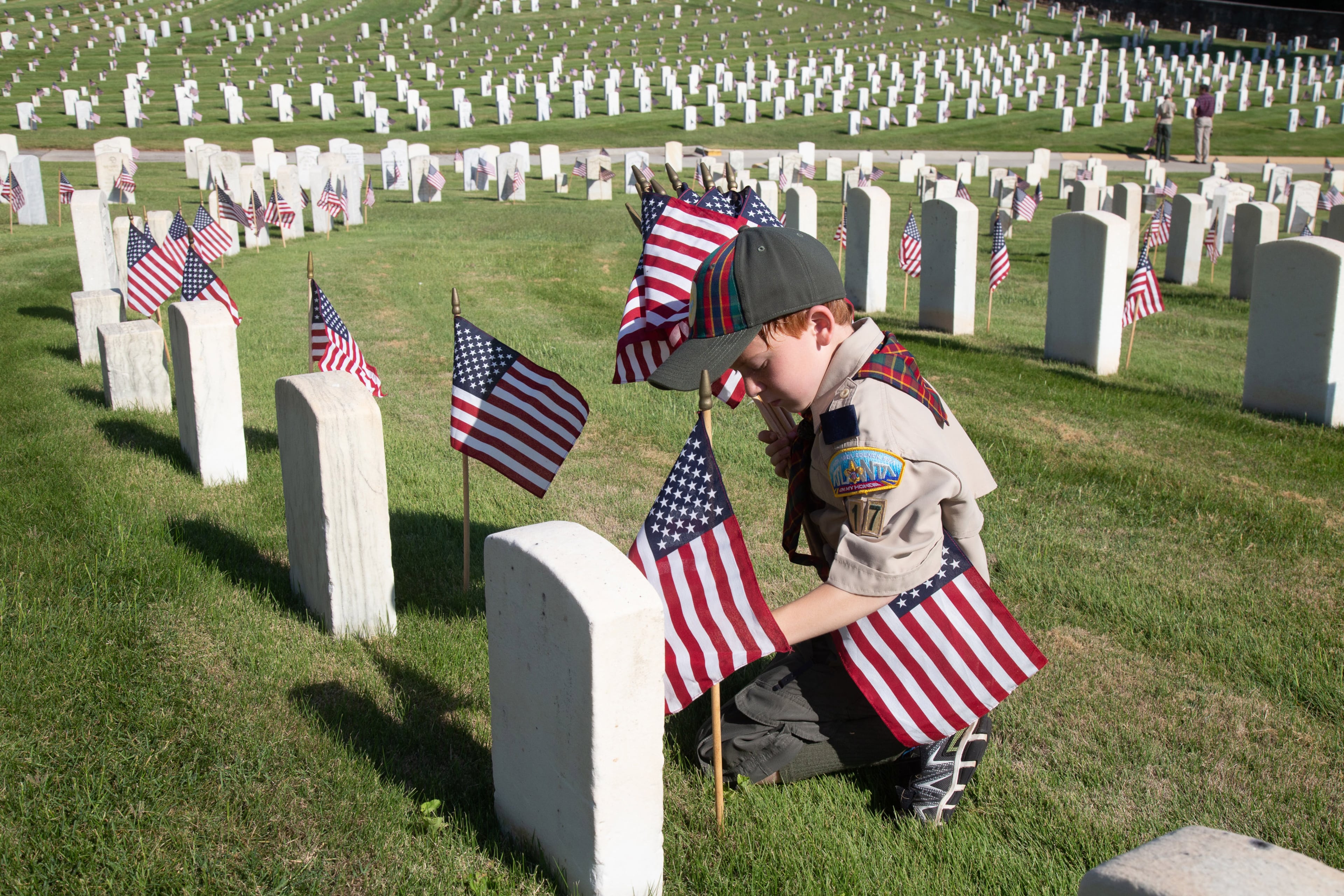 David Landry from pack 417 places an American flag at one of the grave sites at the Marietta National Cemetery on Saturday, May 25, 2019. Scouts placed an American flag at each of the 18,000 cemetery graves in advance of the Memorial Day commemorations. STEVE SCHAEFER / SPECIAL TO THE AJC