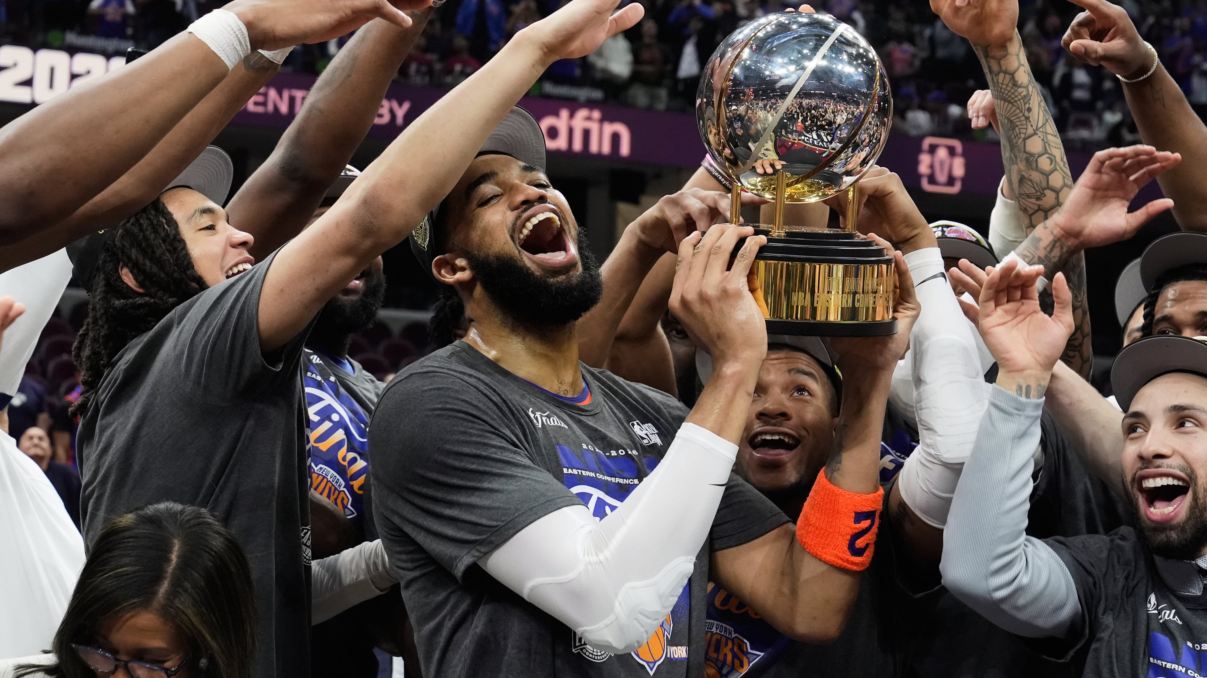 New York Knicks center Karl-Anthony Towns, center, and teammates celebrate after winning Game 4 in the Eastern Conference finals NBA basketball playoffs series against the Cleveland Cavaliers in Cleveland, Monday, May 25, 2026. (AP Photo/Sue Ogrocki)