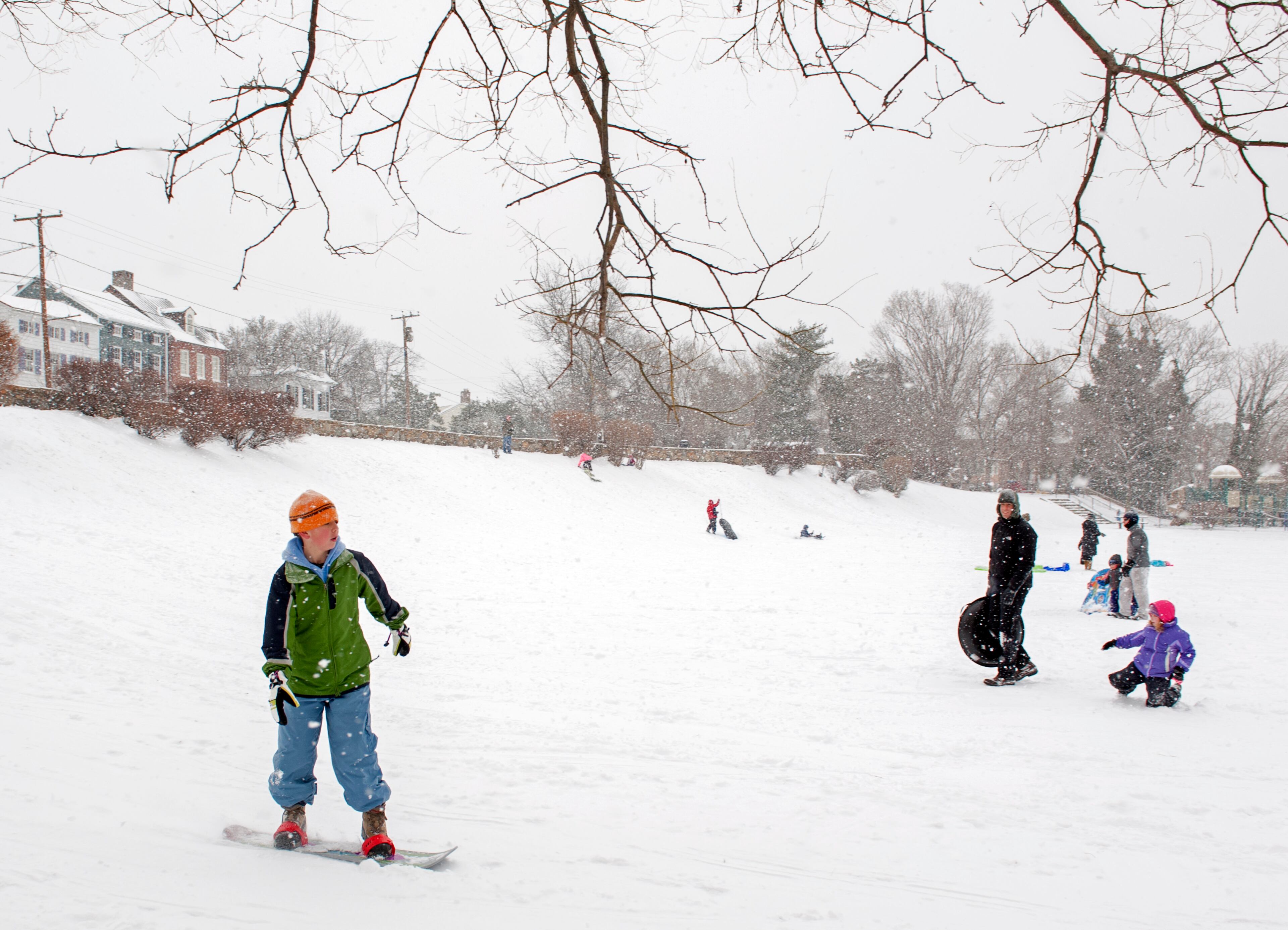 People sled and snowboard down a hill at a park in Alexandria, Va., Monday, March 3, 2014. Winter kept its icy hold on much of the country Monday, with snow falling and temperatures dropping as schools and offices closed and people from the South and Mid-Atlantic to Northeast reluctantly waited out another storm indoors. Four to 8 inches of snow were forecast from Baltimore to Washington _ lower than earlier predictions but enough to cause headaches for the region. (AP Photo/Cliff Owen)