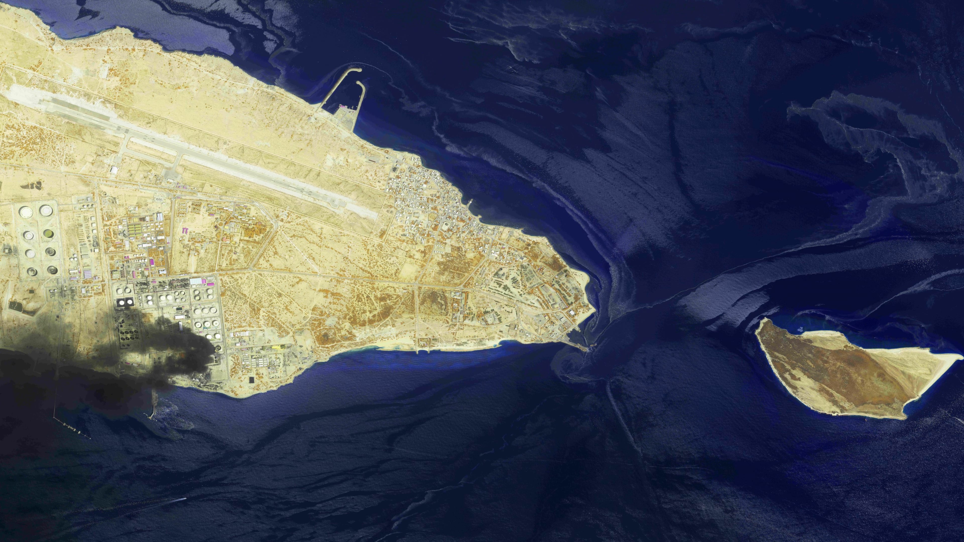 This image from an Airbus Defence and Space's Pléiades Neo satellite shows a fire at an oil refinery on Iran’s Lavan Island, left, and an oil slick in the waters of the Persian Gulf around Shidvar Island, right, April 10, 2026. (Airbus Defence and Space© via AP)