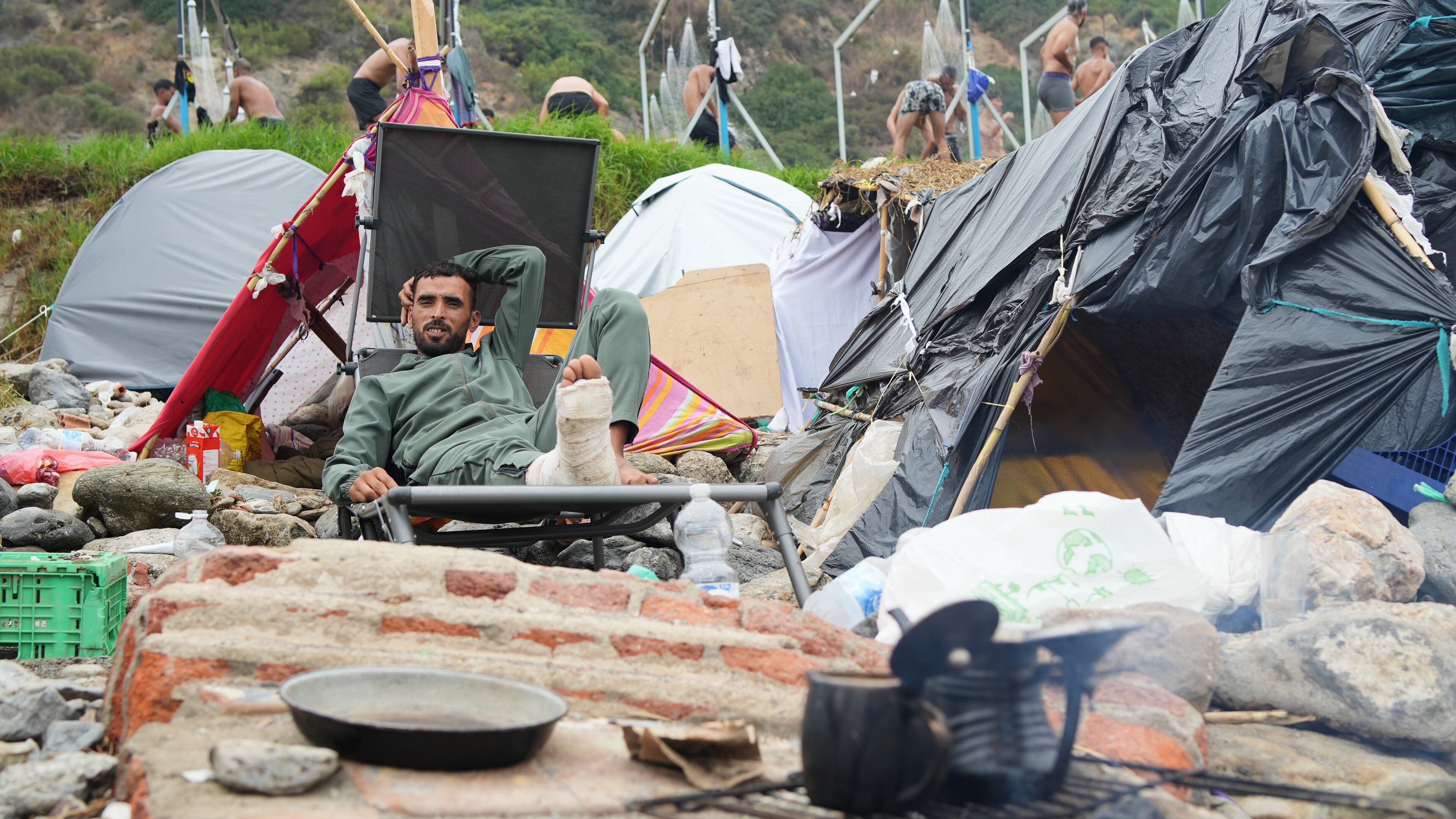 A migrant sits next to his tent at El Trampolín beach in the Spanish exclave of Ceuta, Wednesday, Sept. 2, 2026. (AP Photo/Francis González)