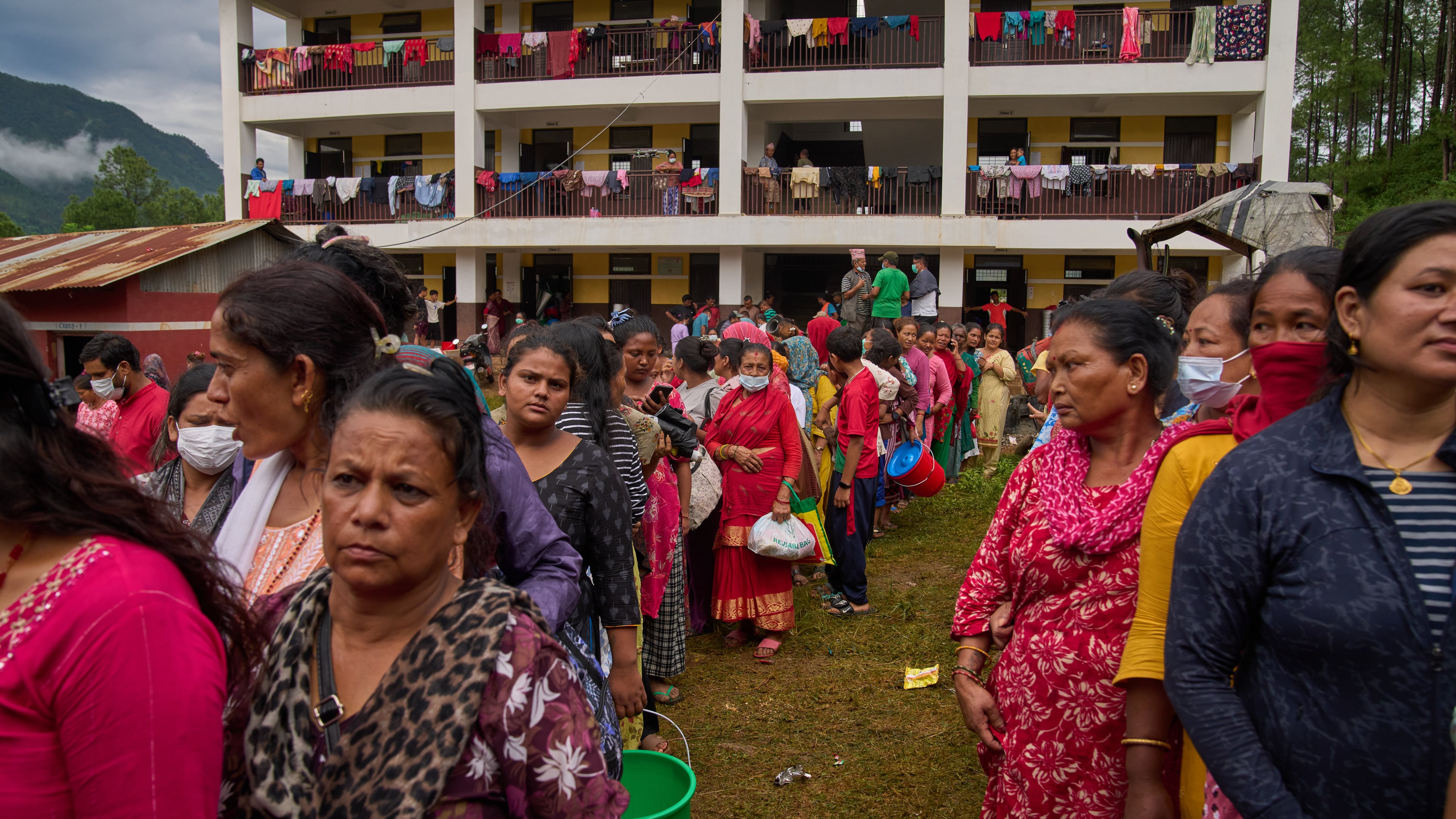 FILE - People affected by recent flash floods line up to receive aid at a school turned into a shelter in Nuwakot district, Nepal, Sept. 3, 2026. (AP Photo/Dar Yasin, File)