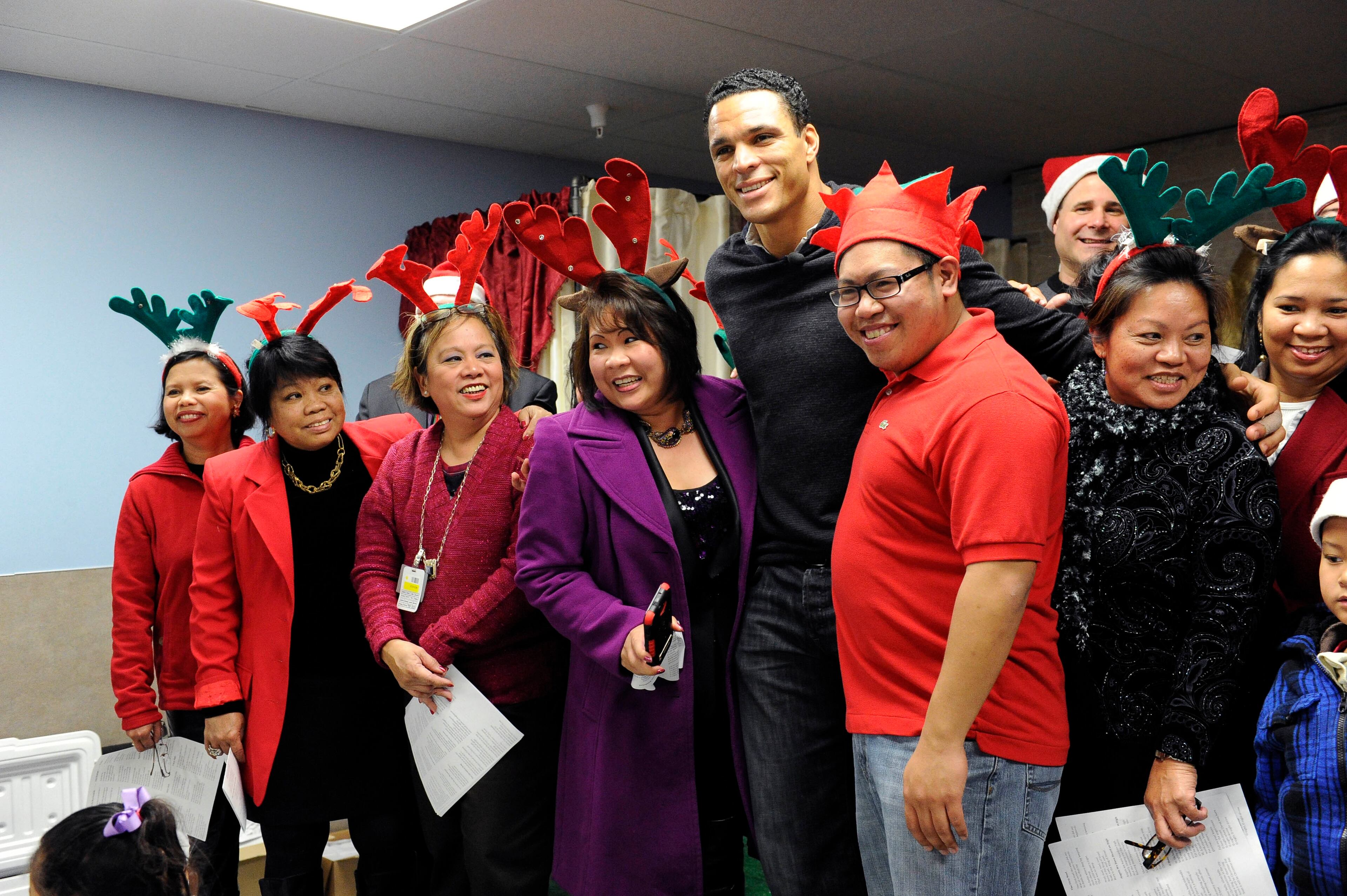Atlanta Falcons player Tony Gonzalez poses with a local church choir that were on had to sing to children at Wal-Mart Tuesday, Dec. 11, 2012, in Suwanee. The Falcons players were participating in the program "Shop with a Jock" in which they provided 37 children from an Atlanta area mission with a $100 gift card and helped them shop.