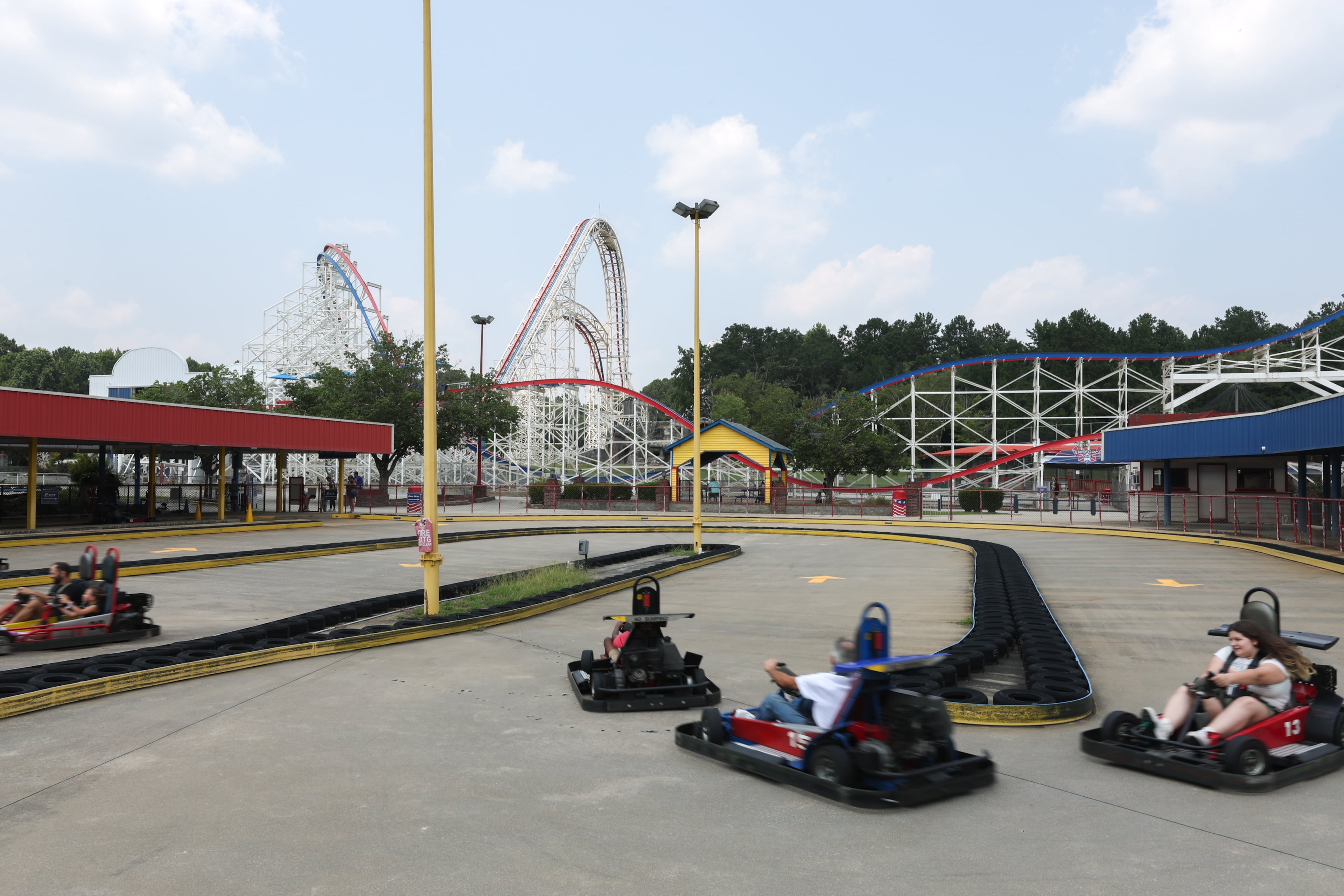 Visitors ride go-karts at Fun Spot in Fayetteville. The park's biggest attraction, a 154-foot-tall roller coaster, is in the background. (Arvin Temkar/AJC)