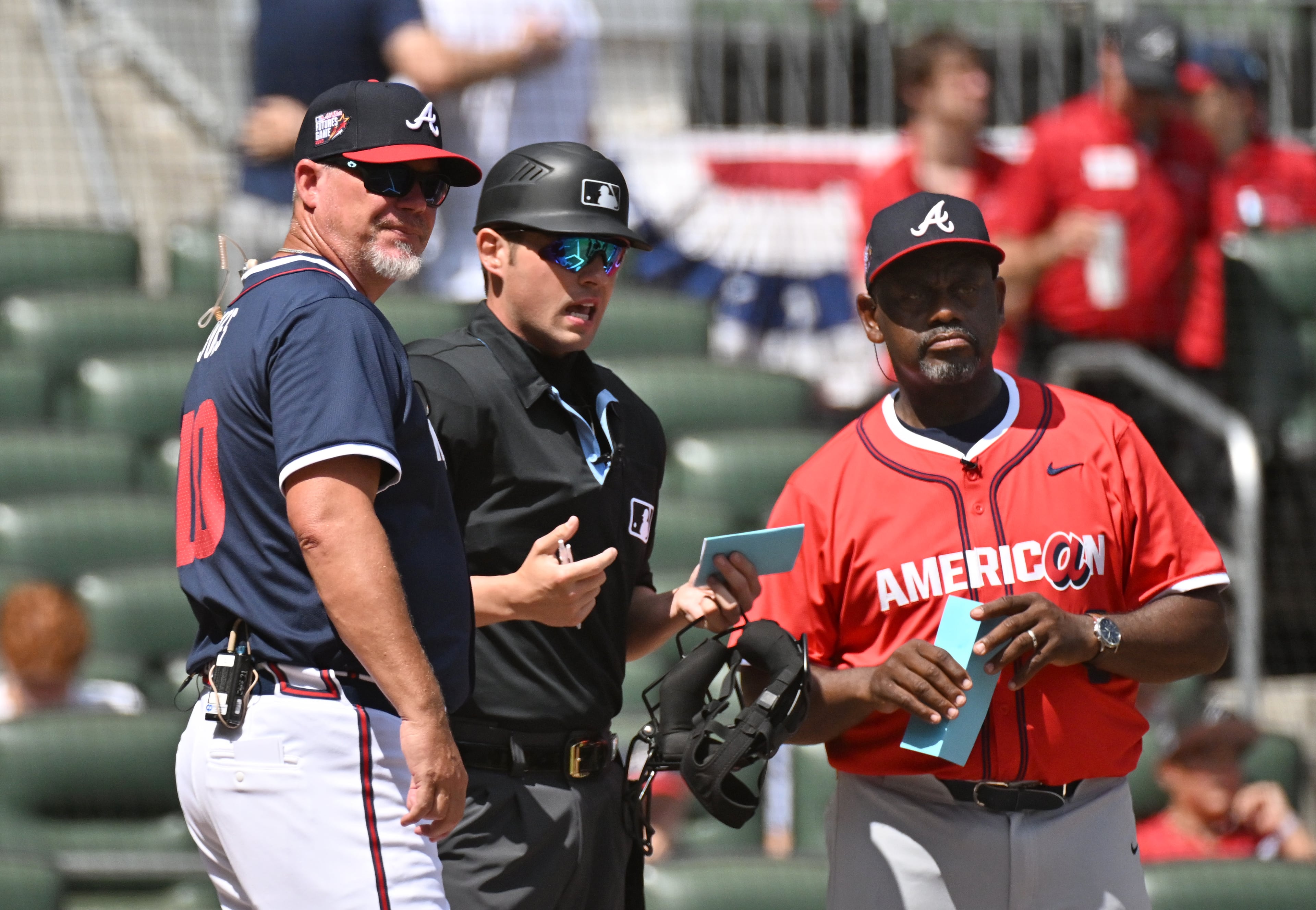 Former Braves Chipper Jones (left) and Marquis Grissom (right) chat with an umpire.