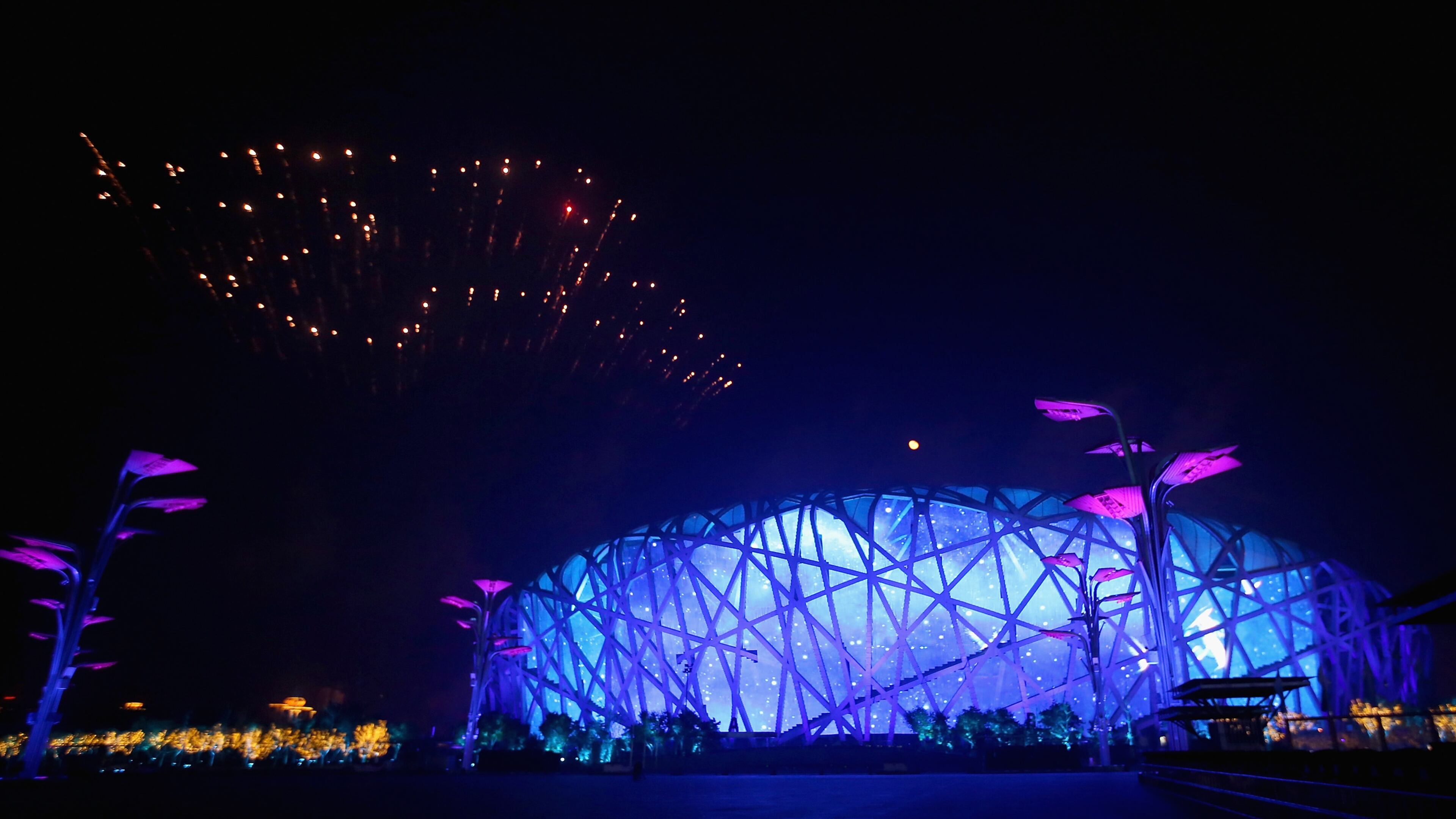 BEIJING, CHINA - NOVEMBER 10: Peace dove fireworks illuminate the sky over the National Stadium, known as 'Bird's Nest', during the Welcome Banquet for 2014 APEC leaders at the National Aquatics Center, known as the Water Cube, on November 10, 2014 in Beijing, China. The 22nd APEC Economic Leaders' Meeting will hold on November 11, 2014 in Beijing, China. (Photo by Feng Li/Getty Images)