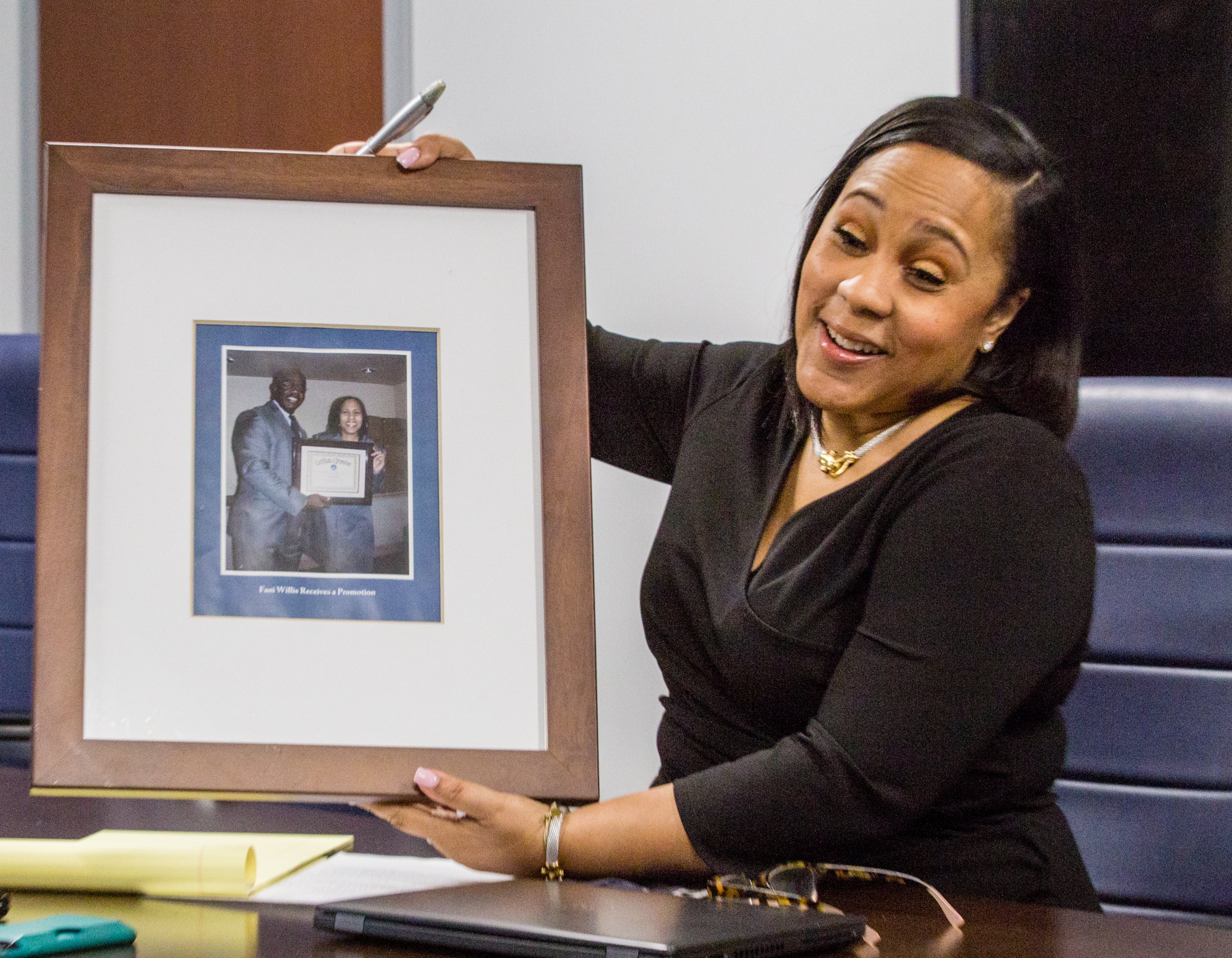 Fulton County's newly elected District Attorney Fani Willis shows the photo left behind by former DA Paul Howard, who was once her boss, in a conference room at the Fulton County Courthouse in downtown Atlanta on Thursday, Feb 18, 2021. The former DA and his team took all the furniture and left behind boxes of unprocessed cases and 10,000 open cases dating back to 2017. (Jenni Girtman for The Atlanta Journal-Constitution)