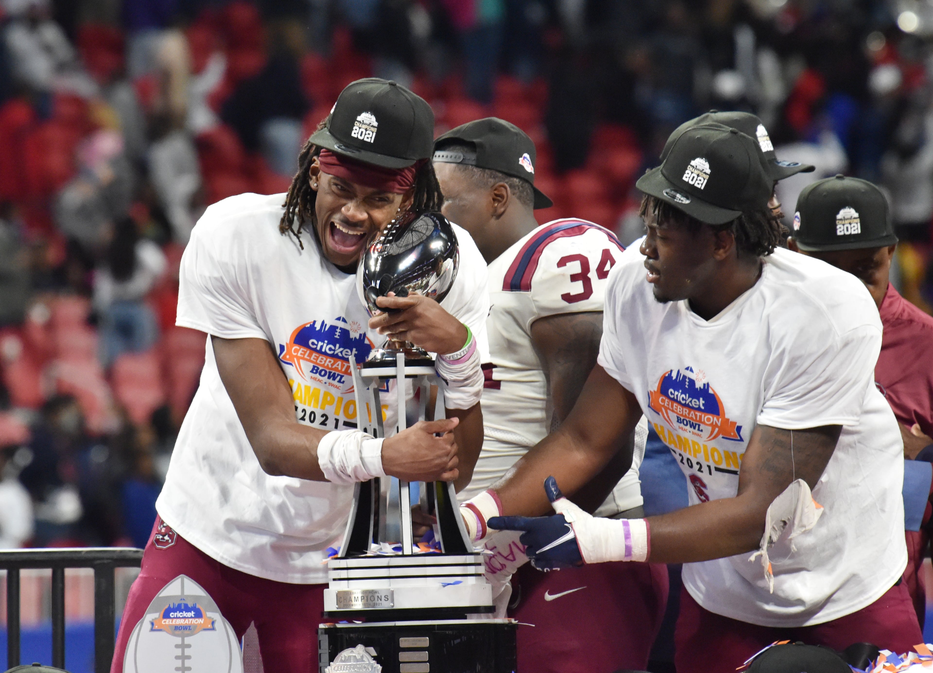 South Carolina State's wide receiver Shaquan Davis (1) hugs the championship trophy after his team won the 2021 Cricket Celebration Bowl at Mercedes-Benz Stadium in Atlanta on Saturday, December 18, 2021. South Carolina State won 31-10 over Jackson State. (Hyosub Shin / Hyosub.Shin@ajc.com)