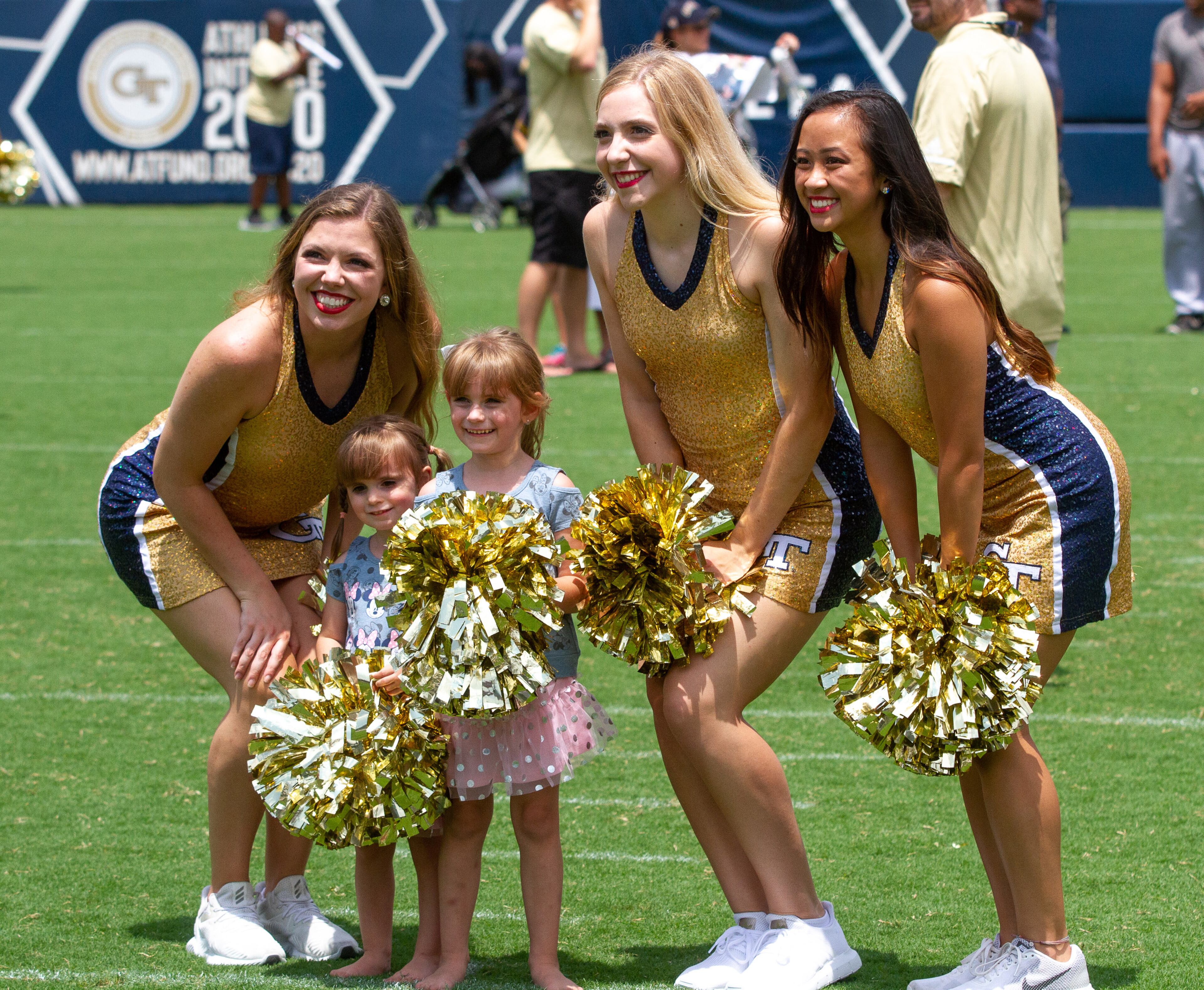 Avery Winter, 2, and her sister Caroline, 4, get their photograph taken with Georgia Tech's dance team during Fan Day at Bobby Dodd Stadium Saturday, August 3, 2019. STEVE SCHAEFER / SPECIAL TO THE AJC