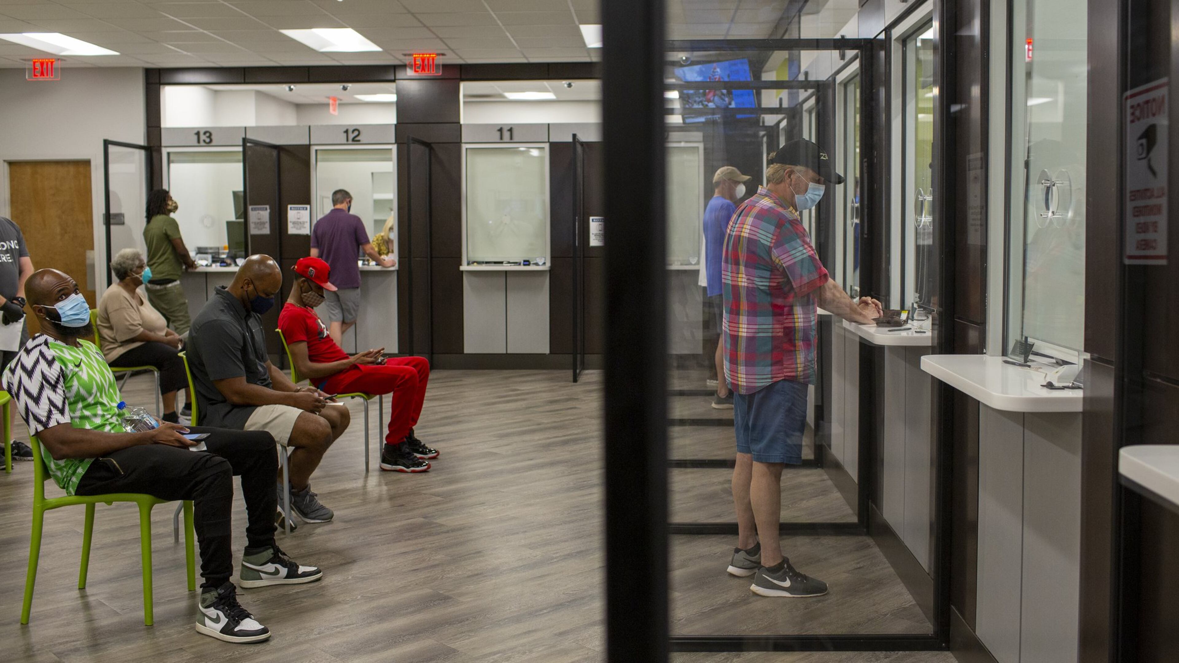 Dave Fletcher, right, meets with an attendant at the Cobb Tax Commission Office in Marietta, Georgia, on Monday, June 29, 2020. New social distancing signage, sanitation equipment and Plexiglass barriers were installed at the Cobb Tax Commission Office in Marietta, Georgia, and were paid for by the Coronavirus Aid, Relief, and Economic Security Act, also known as the CARES Act. (REBECCA WRIGHT FOR THE ATLANTA JOURNAL-CONSTITUTION)