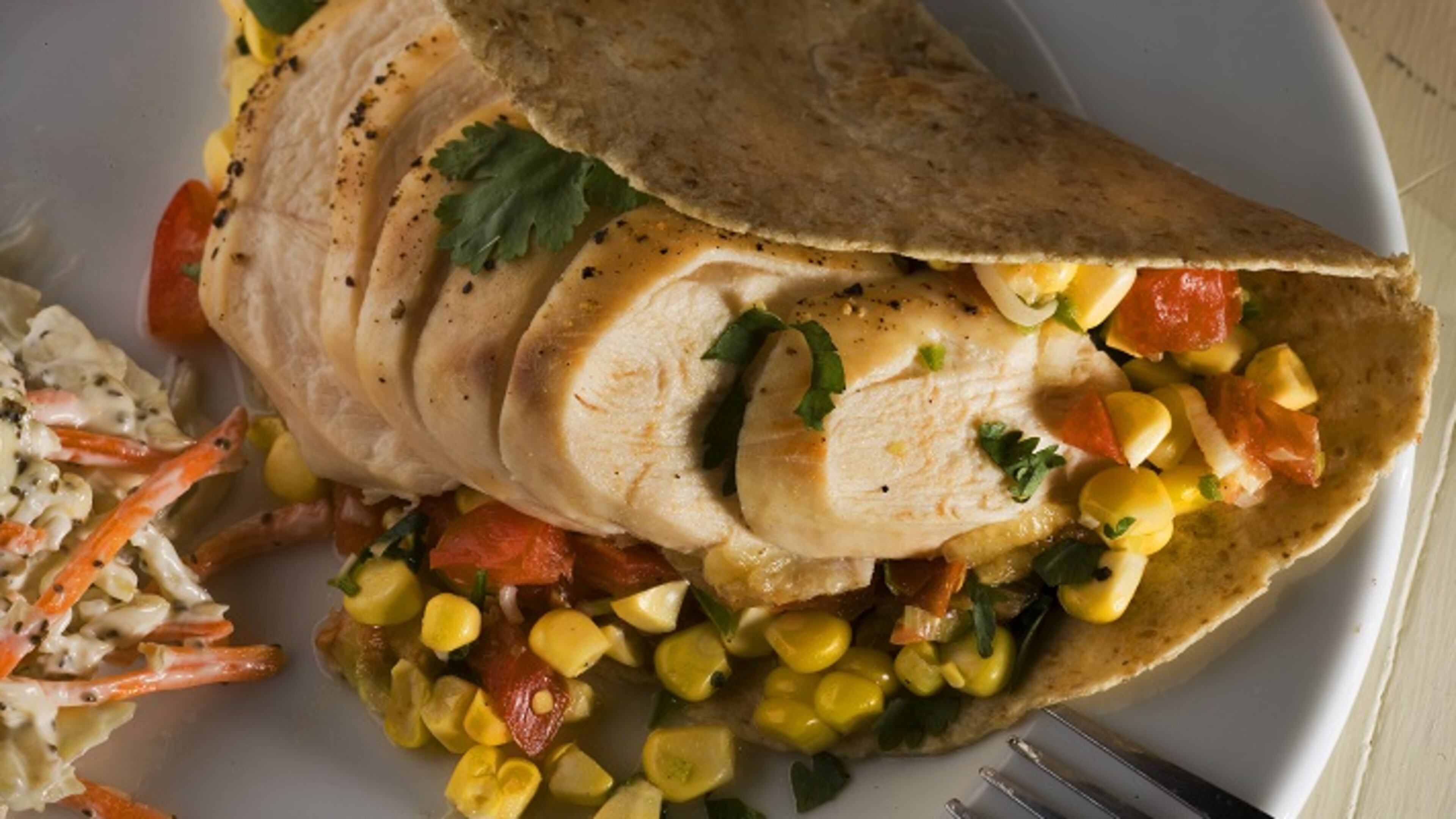 Corn and tomatoes make up a summery salsa for a grilled chicken wrap, an easy dinner for lazy days. (Bob Fila/Chicago Tribune/TNS)