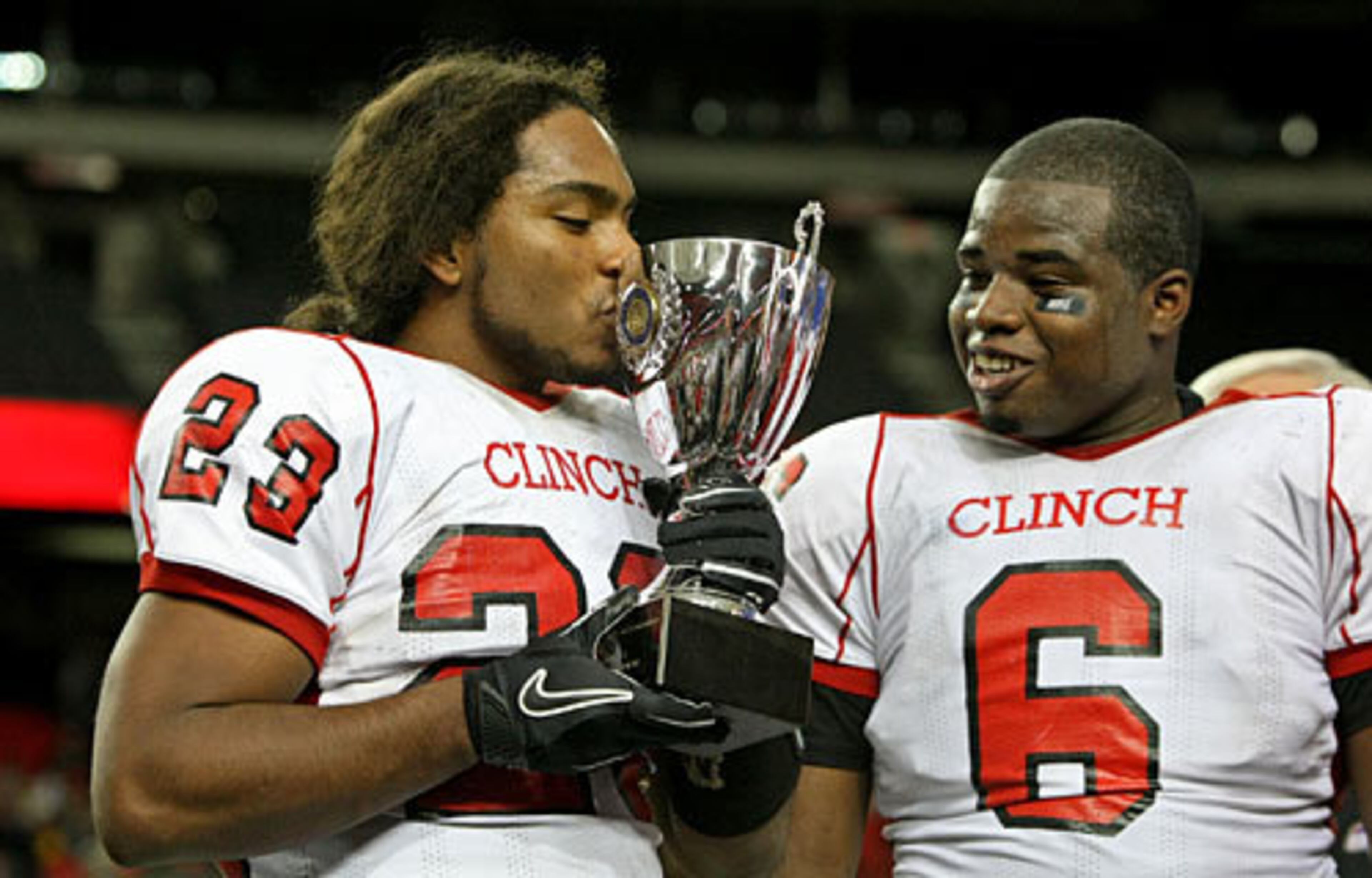 Clinch County quarterback Tray Dorsey (23) kisses the Class A trophy next to linebacker Trey Richardson as they celebrate their 24-14 win over Savannah Christian in the Class A final Saturday afternoon at the Georgia Dome in Atlanta, Ga., Dec. 11, 2010.
