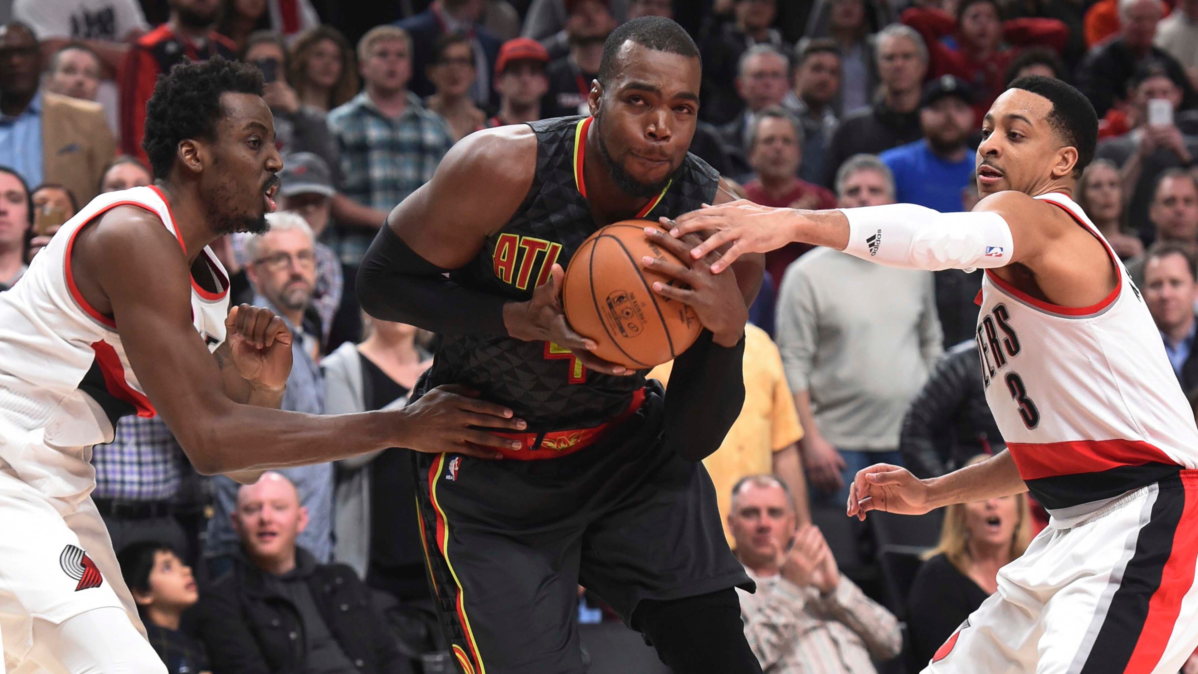 Atlanta Hawks forward Paul Millsap drives to the basket on Portland Trail Blazers forward Al-Farouq Aminu and guard C.J. McCollum in the second half of an NBA basketball game in Portland, Ore., Monday, Feb 13, 2017. Atlanta won in overtime 109-104. (AP Photo/Steve Dykes)