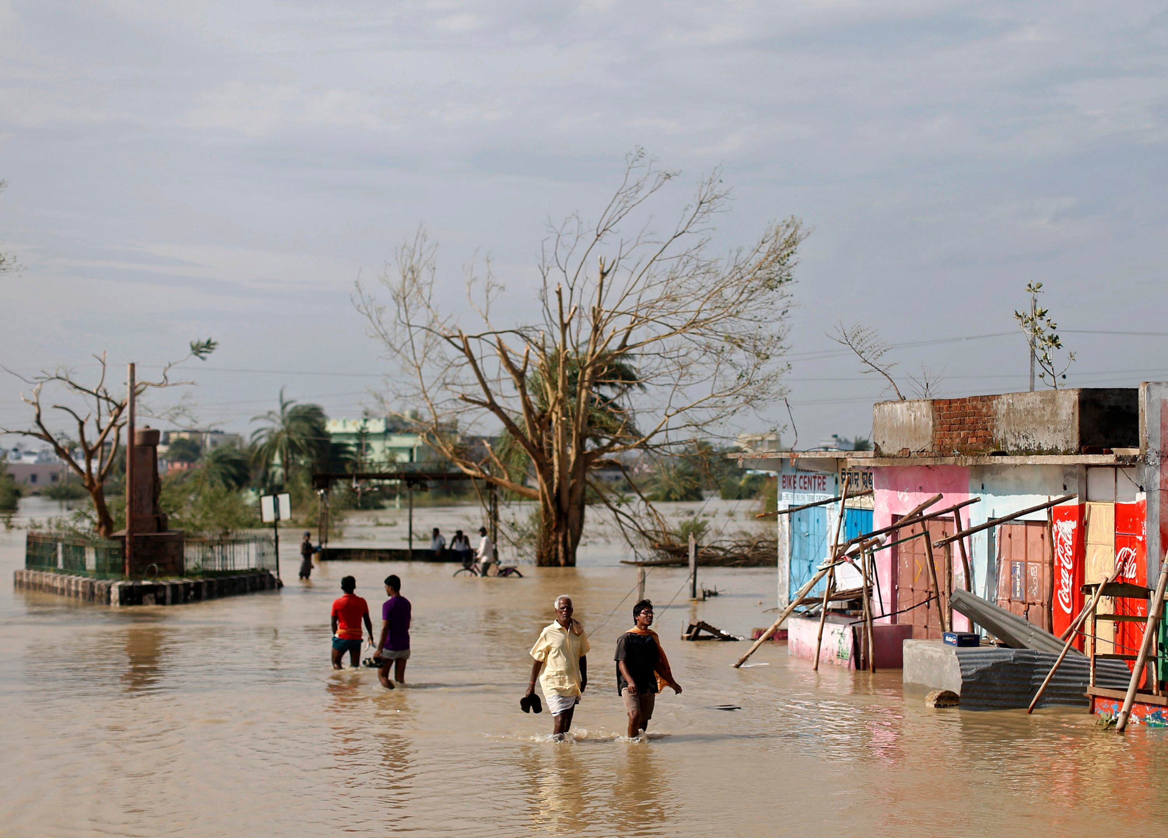 Residents wade through a flooded road after Cyclone Phailin hit Gopalpur in Ganjam district in the eastern Indian state of Odisha October 13, 2013. India's strongest storm in 14 years left a trail of destruction along the country's east coast on Sunday, but little loss of life was reported after close to a million people took refuge in shelters. Cyclone Phailin was expected to dissipate within 36 hours, losing momentum as it headed inland after making landfall on Saturday from the Bay of Bengal, bringing winds of more than 200 kph (125 mph) to rip up homes and tear down trees. REUTERS/Ahmad Masood