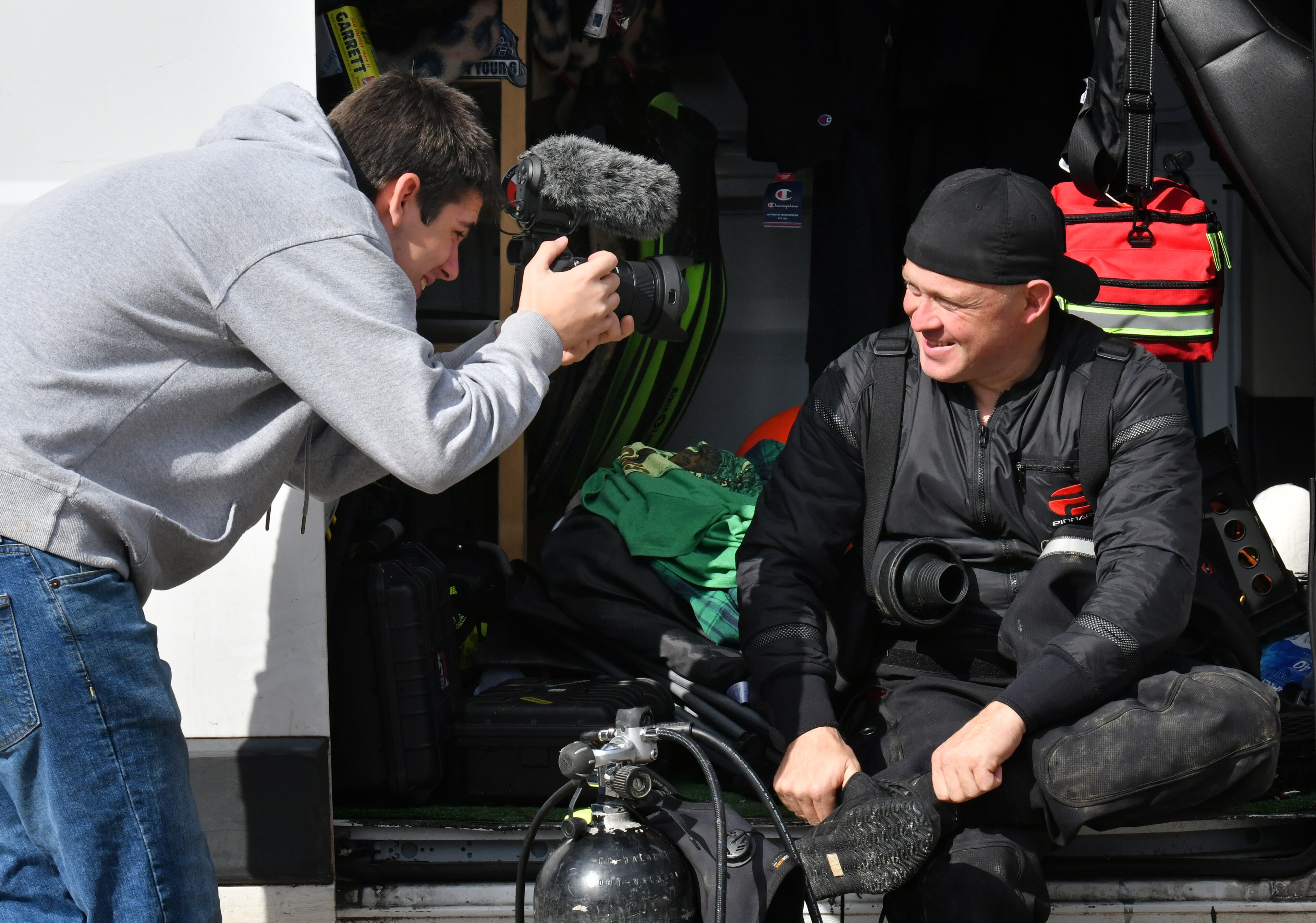 A fellow scuba diver Britain Lockhart (left) films as Jeremy Sides prepares to dive in the Chattahoochee River for his YouTube channel, Exploring with Nug. Sides first began searching creeks and rivers for gold nuggets and Civil War artifacts, but has become adept at locating missing persons and solving cold cases. (Hyosub Shin / Hyosub.Shin@ajc.com)