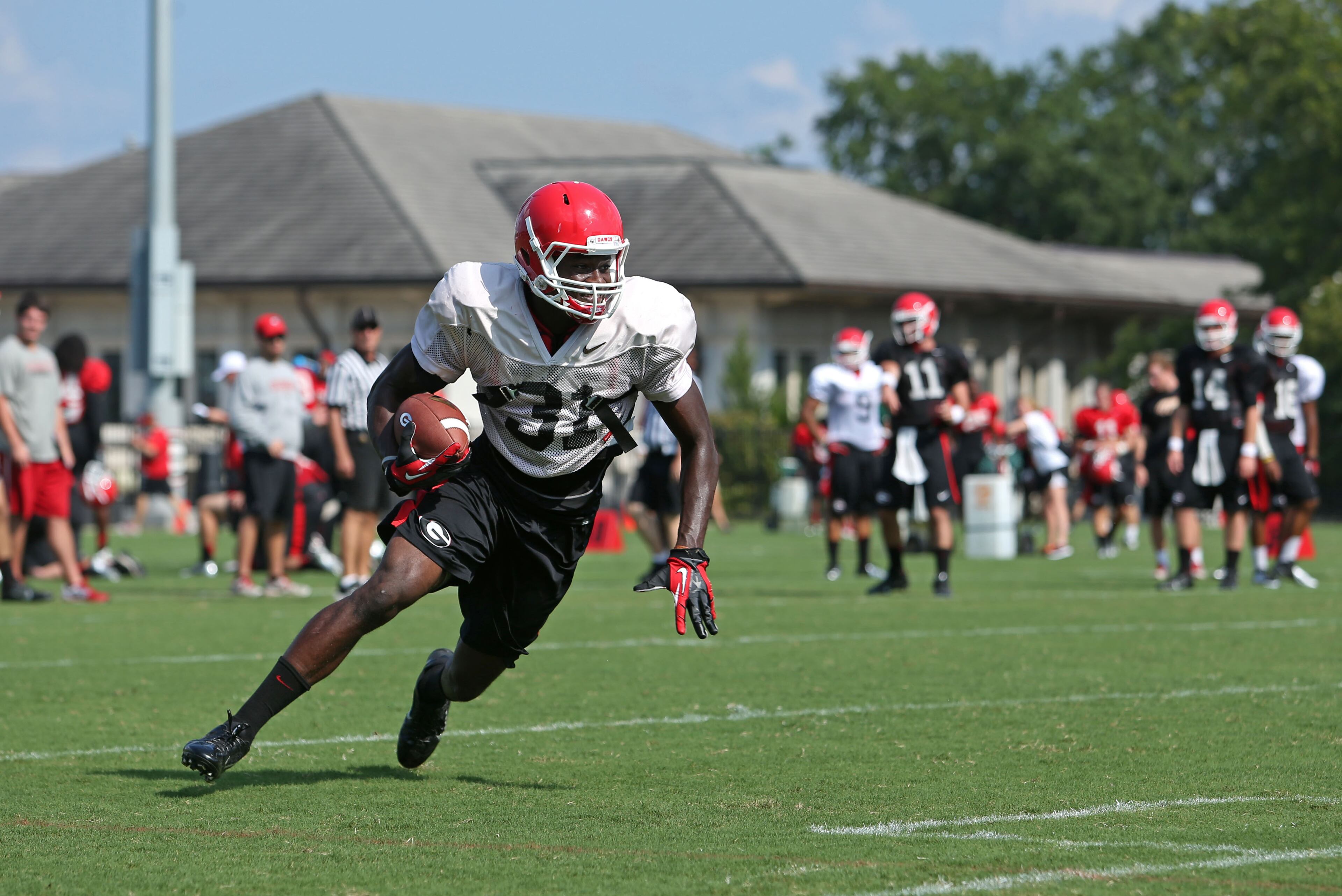University of Georgia flanker Chris Conley (31) runs after a catch from quarterback Aaron Murray (11, right) during preseason practice at the University of Georgia Friday afternoon in Athens, Ga., August 23, 2013. JASON GETZ / JGETZ@AJC.COM