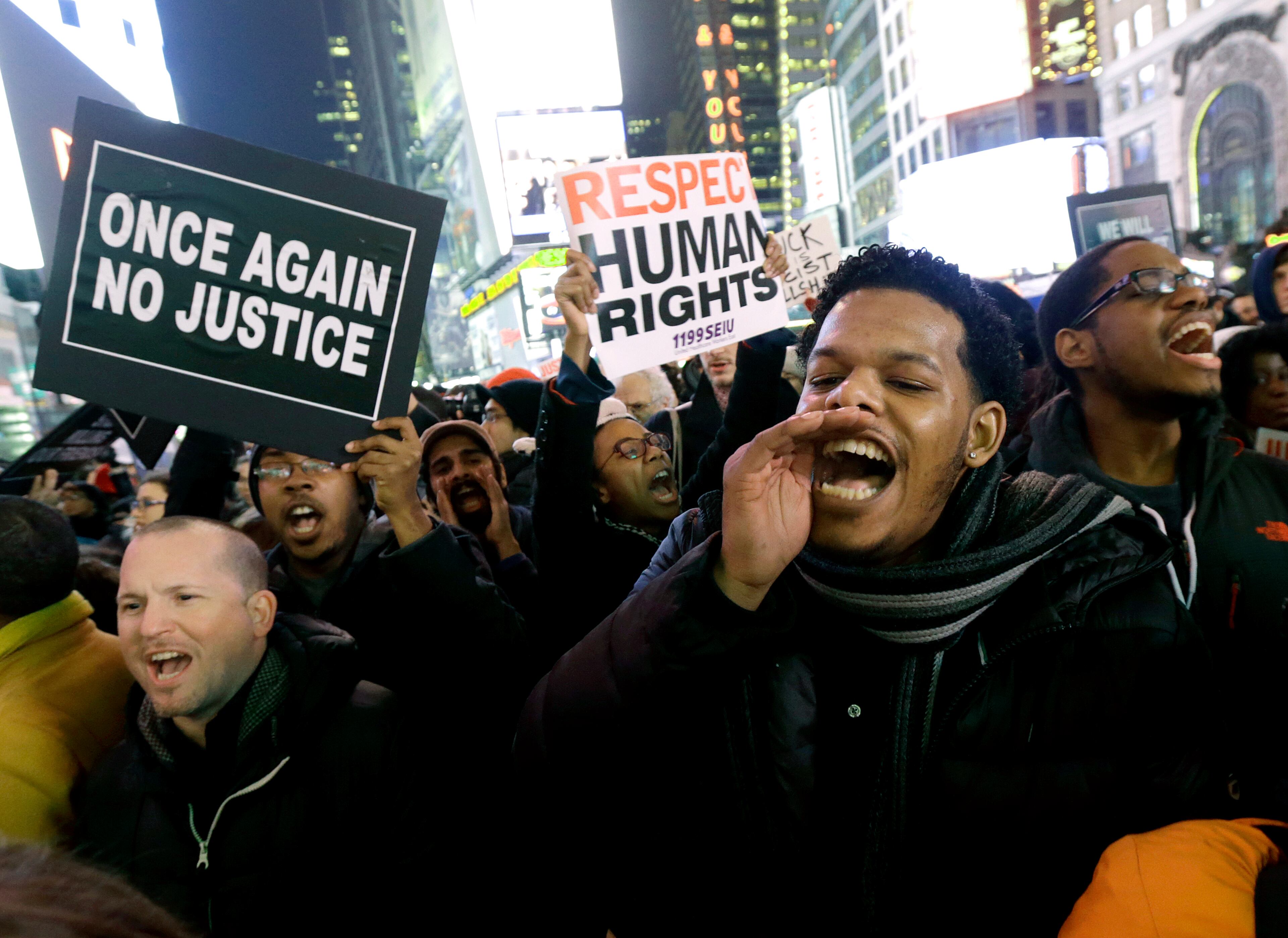 Protestors shout at Times Square after it was announced that the New York City police officer involved in the death of Eric Garner is not being indicted, Wednesday, Dec. 3, 2014, in New York. A grand jury cleared the white New York City police officer Wednesday in the videotaped chokehold death of Garner, an unarmed black man, who had been stopped on suspicion of selling loose, untaxed cigarettes, a lawyer for the victim's family said. A video shot by an onlooker and widely viewed on the Internet showed the 43-year-old Garner telling a group of police officers to leave him alone as they tried to arrest him. The city medical examiner ruled Garner's death a homicide and found that a chokehold contributed to it. (AP Photo/Julio Cortez)