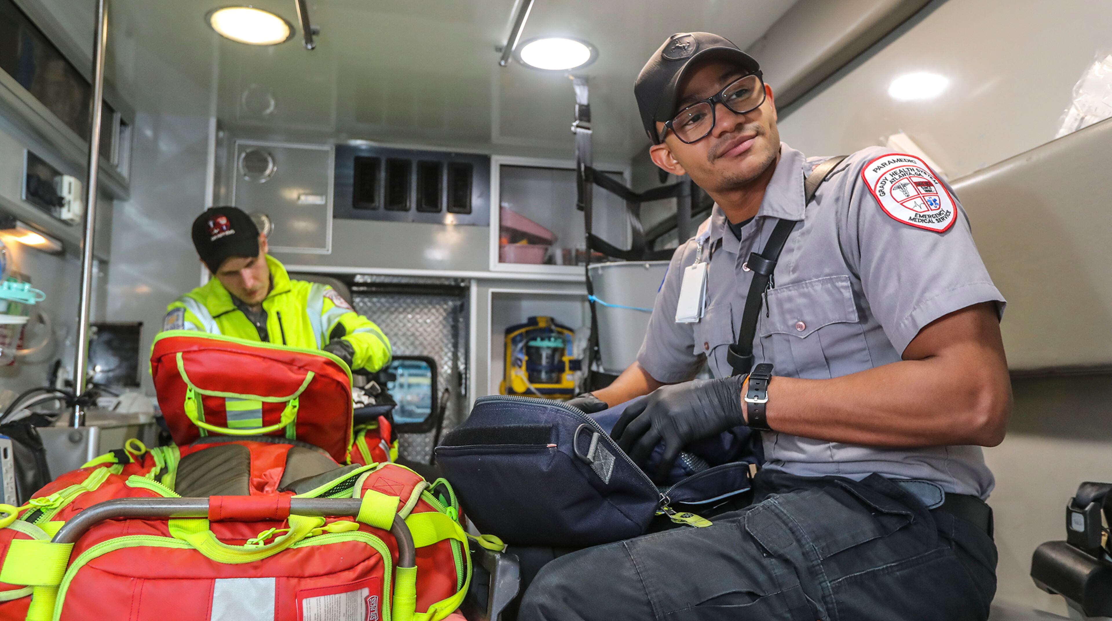 May 21, 2020 Atlanta: Grady EMS Advanced EMT, Ben Jackson (left) and paramedic, Justin Vidican (right). EMS Advanced EMT, Ben Jackson said, "We're going to the same calls,handling some new stuff, but more than anything we've been out, we've been present in the city, we've been showing people we're still out here taking care of them. Nothing's changed, we're still out here." Paramedic, Justin Vidican commented on the pandemic saying, "It's really showed me how much we're needed in this city. The call volume has increased, I really feel the value of my job doing this day after day.I still love it. I still love it, I'll continue to love it throughout the years to come."
JOHN SPINK/JSPINK@AJC.COM