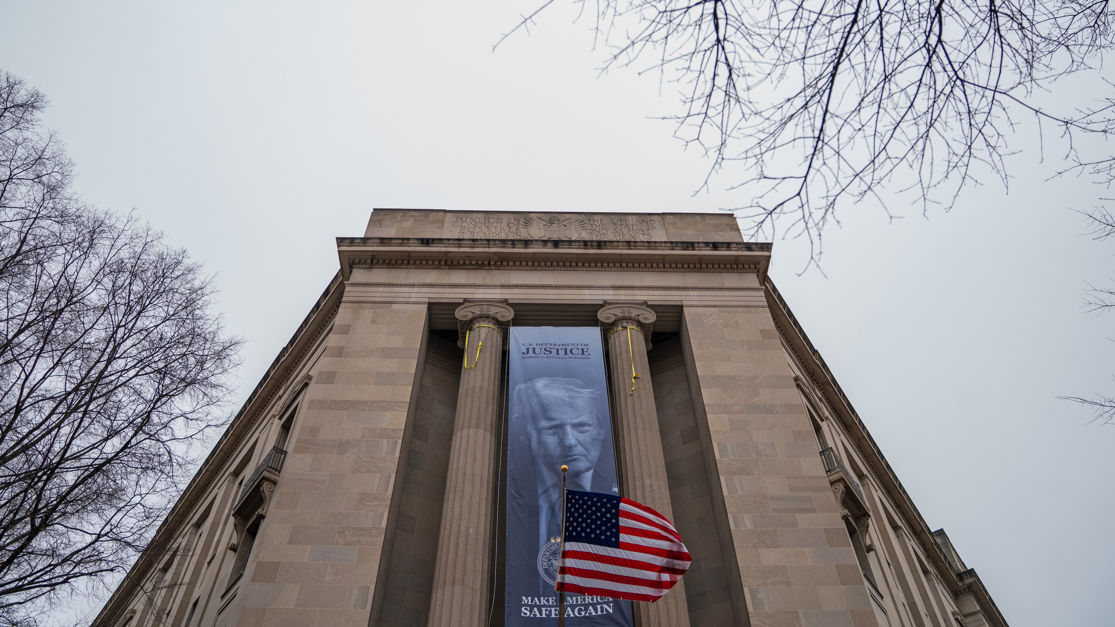 A banner showing President Donald Trump is hung from the Department of Justice, Thursday, Feb. 19, 2026, in Washington. (AP Photo/Allison Robbert)
