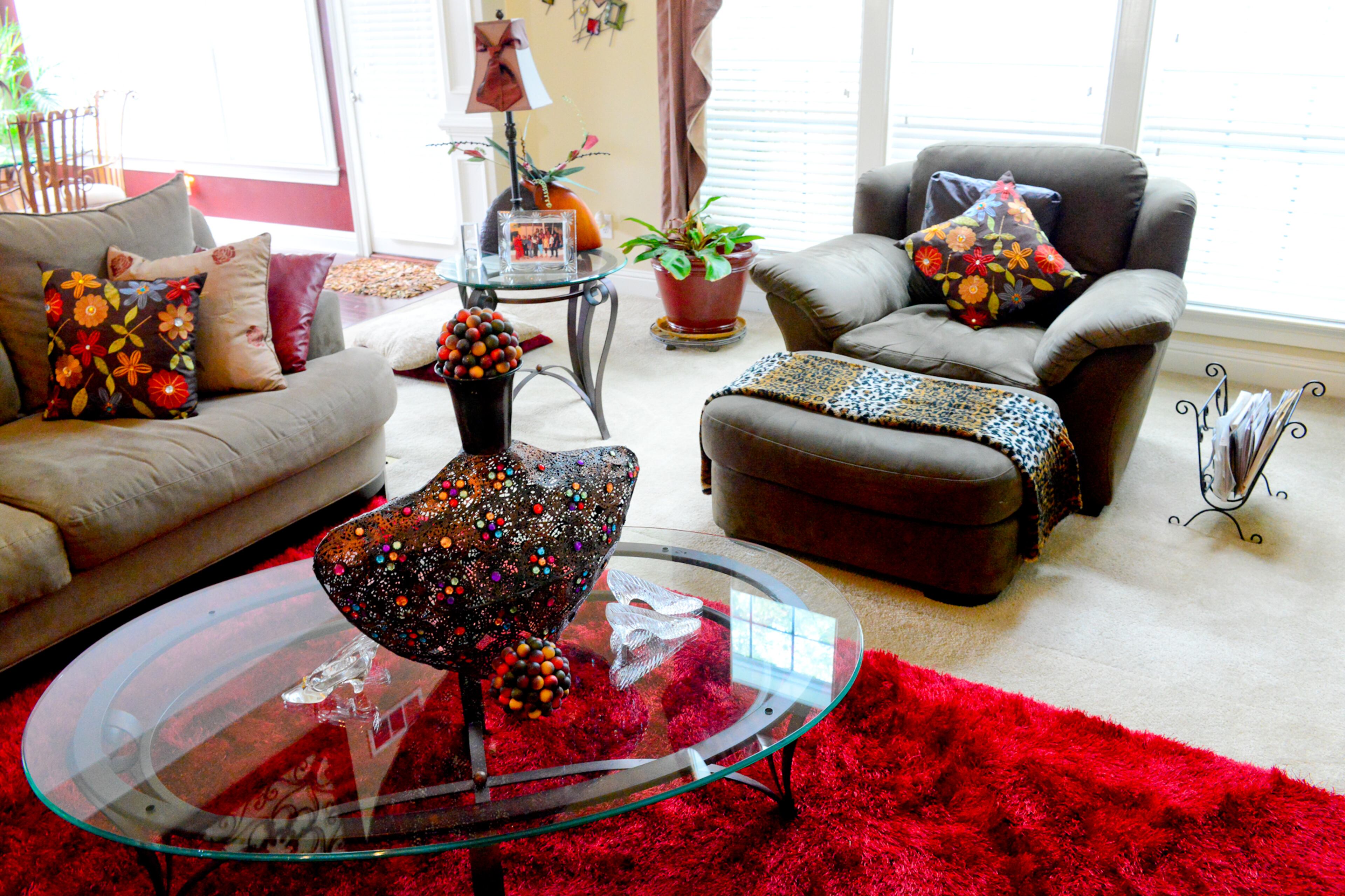 A ruby red rug from Garden Ridge anchors the family room, which includes furniture from Rooms To Go and a coffee table centerpiece from Pier 1 Imports.