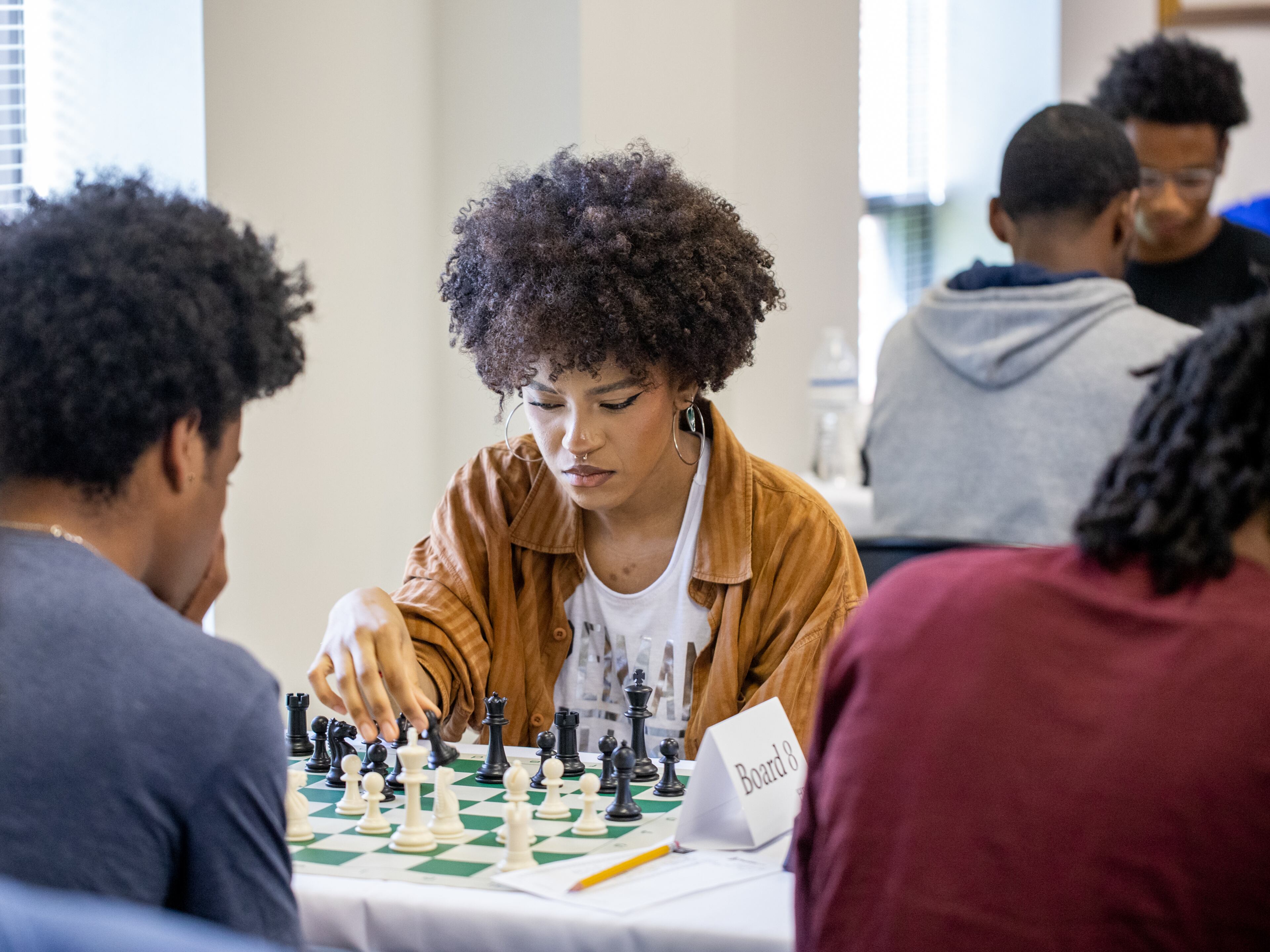 Jamila Am Thompson moves her pawn during the first round of the inaugural HBCU Chess Classic at Morris Brown College on Saturday, April 22, 2023. The tournament brought together students from Morehouse, Clark Atlanta, Spelman and other historically black colleges and universities. (Jenni Girtman for The Atlanta Journal-Constitution)