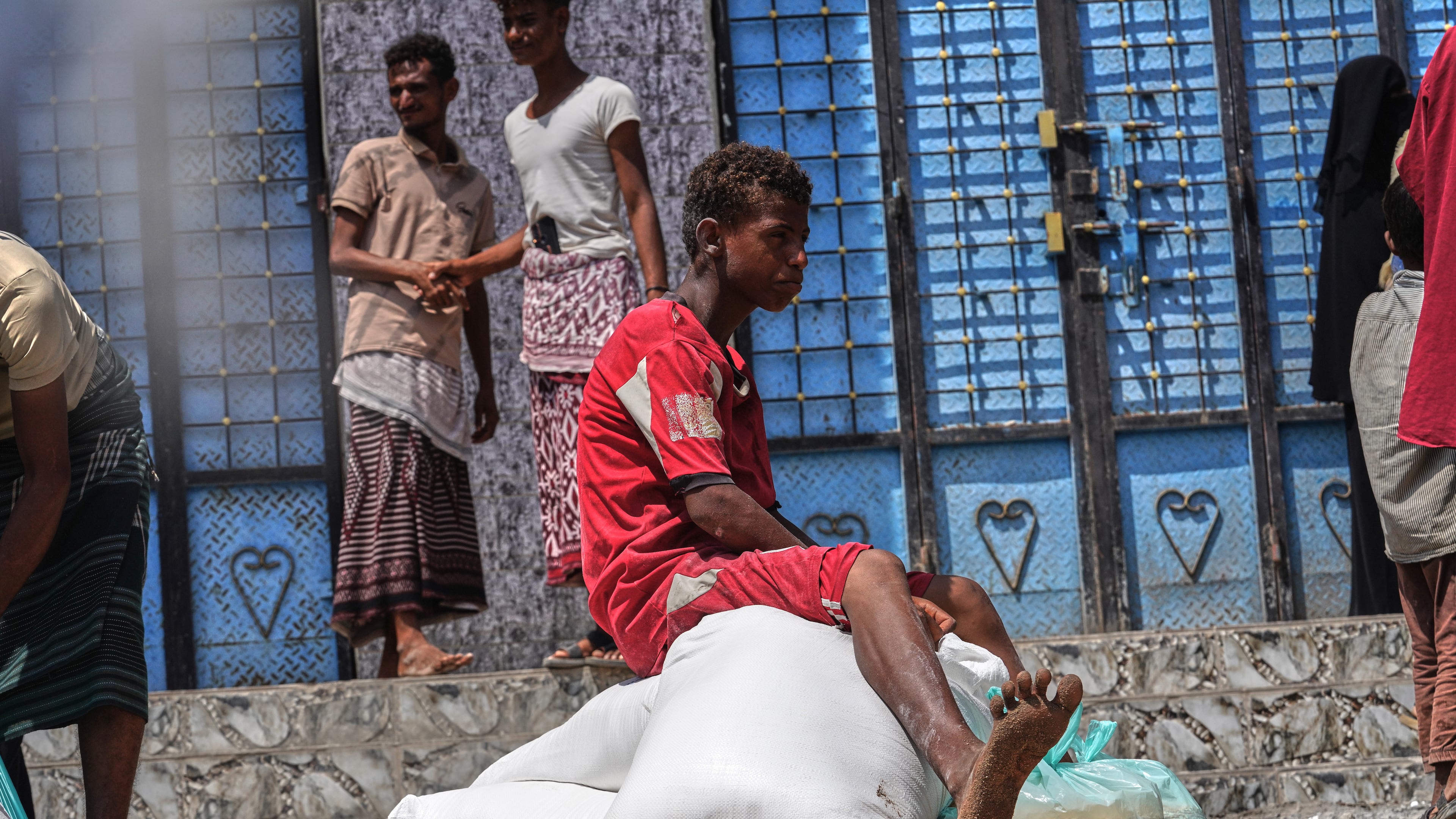 A displaced Yemeni boy sits on sacks of food aid in the Salah al-Din area on the outskirts of Aden, Yemen, Sunday, Oct. 25, 2026. (AP Photo/Abdulnasser Alseddik)