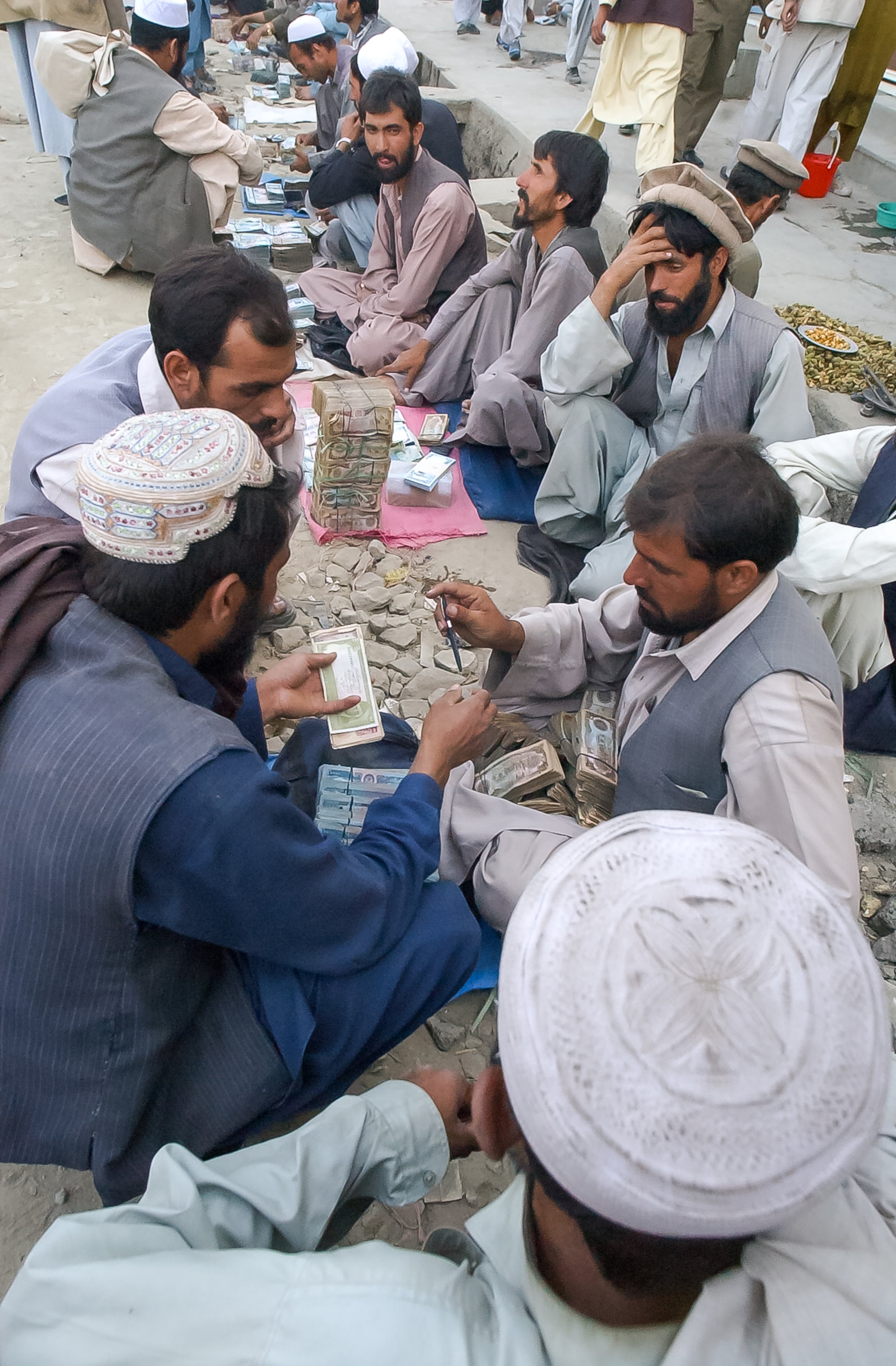 KABUL, AFGHANISTAN: Money changers line a street in Kabul's main bazaar as they conduct business Saturday, Sept. 7, 2002. At the time, one U.S. dollar equaled about 40,000 Afghanis, but the rate fluctuated greatly day-to-day. (Bita Honarvar / The Atlanta Journal-Constitution)