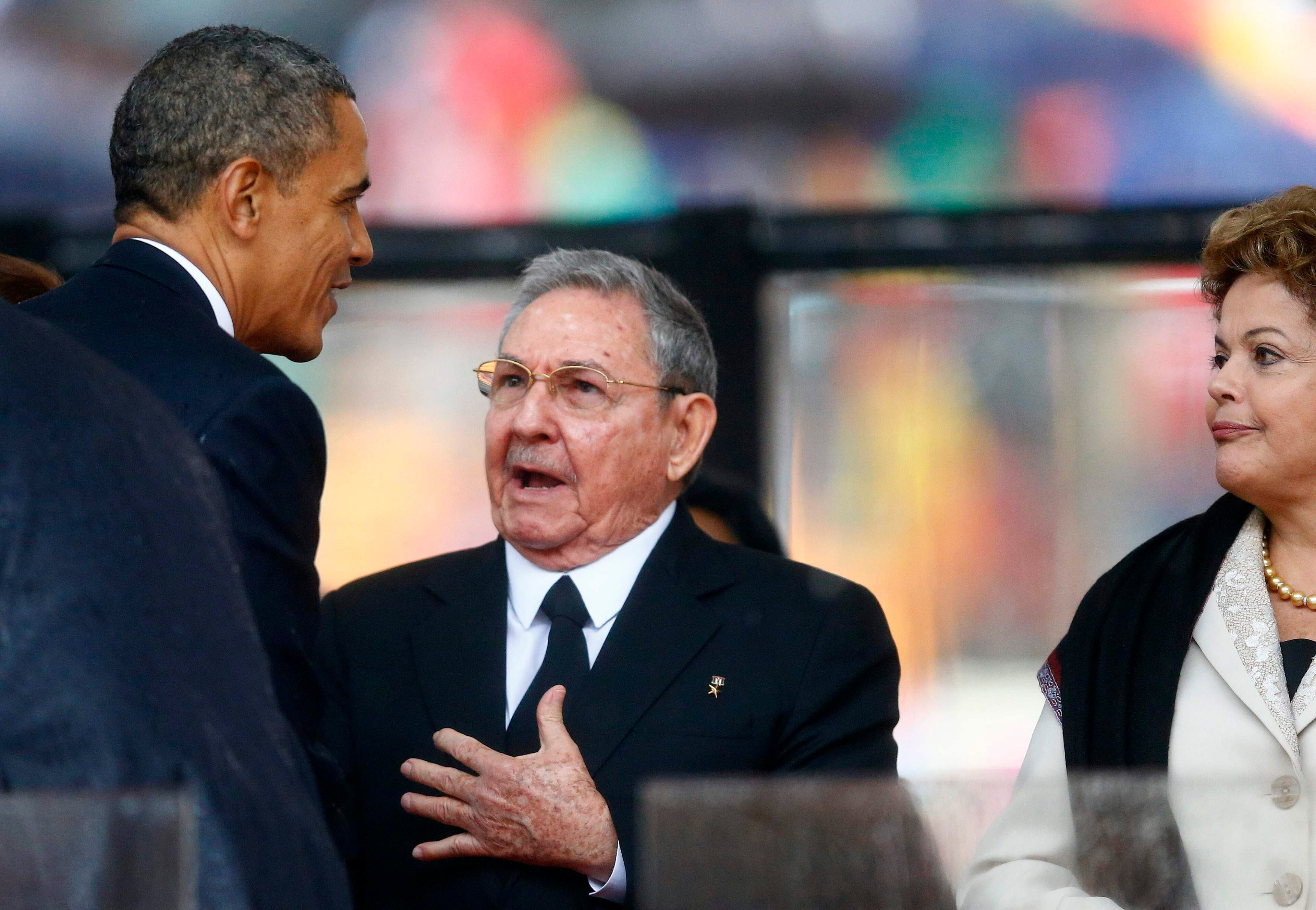 U.S. President Barack Obama (L) greets Cuban President Raul Castro (C) before giving his speech, as Brazil's President Dilma Rousseff looks on, at the memorial service for late South African President Nelson Mandela at the First National Bank soccer stadium, also known Soccer City, in Johannesburg December 10, 2013. Obama shook the hand of Castro at a memorial for Mandela on Tuesday, a rare gesture between the leaders of two nations at loggerheads for more than half a century. REUTERS/Kai Pfaffenbach
