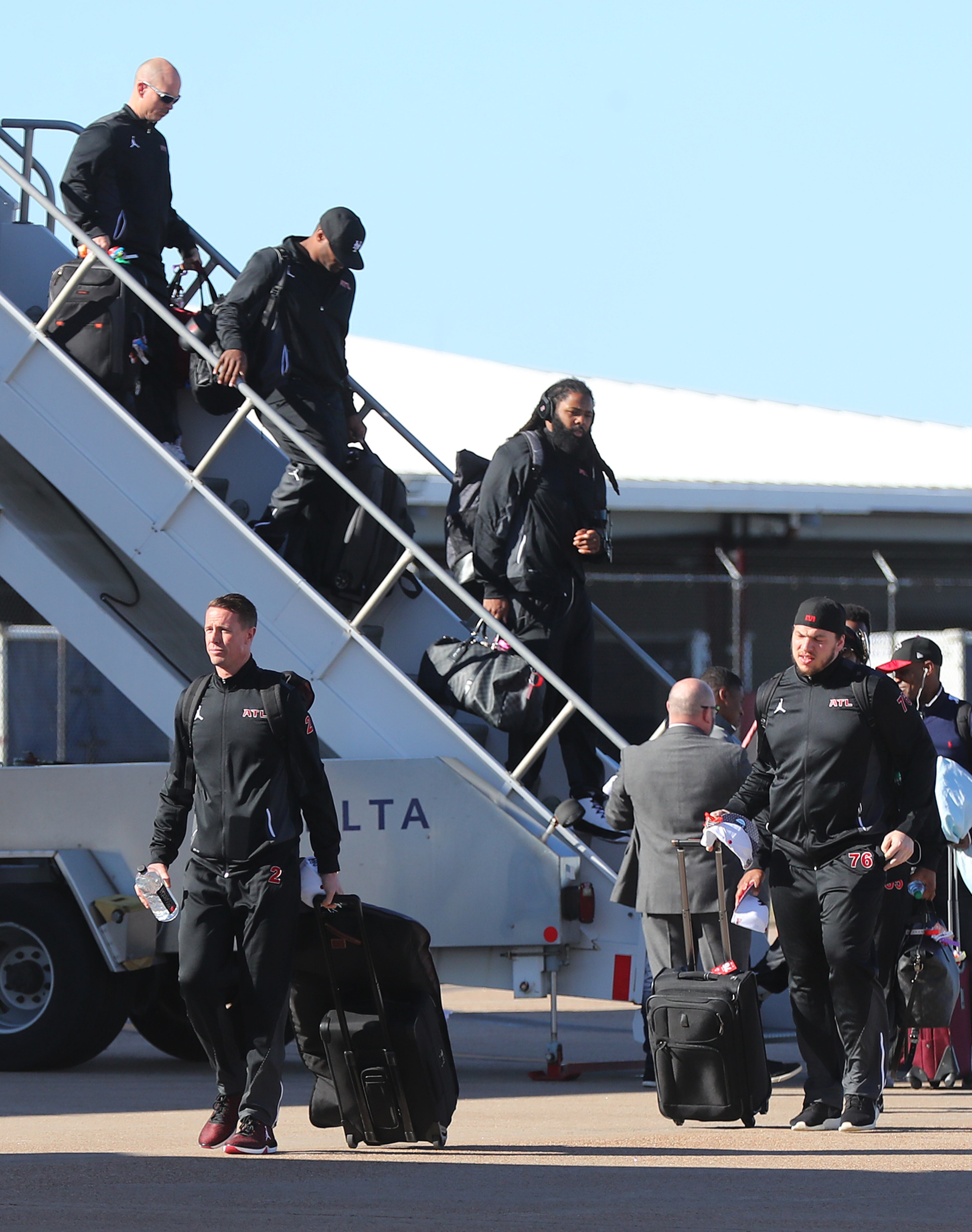Matt Ryan (left) is one of the first off the plane arriving at George W. Bush Intercontinental Airport for the Super Bowl Sunday.