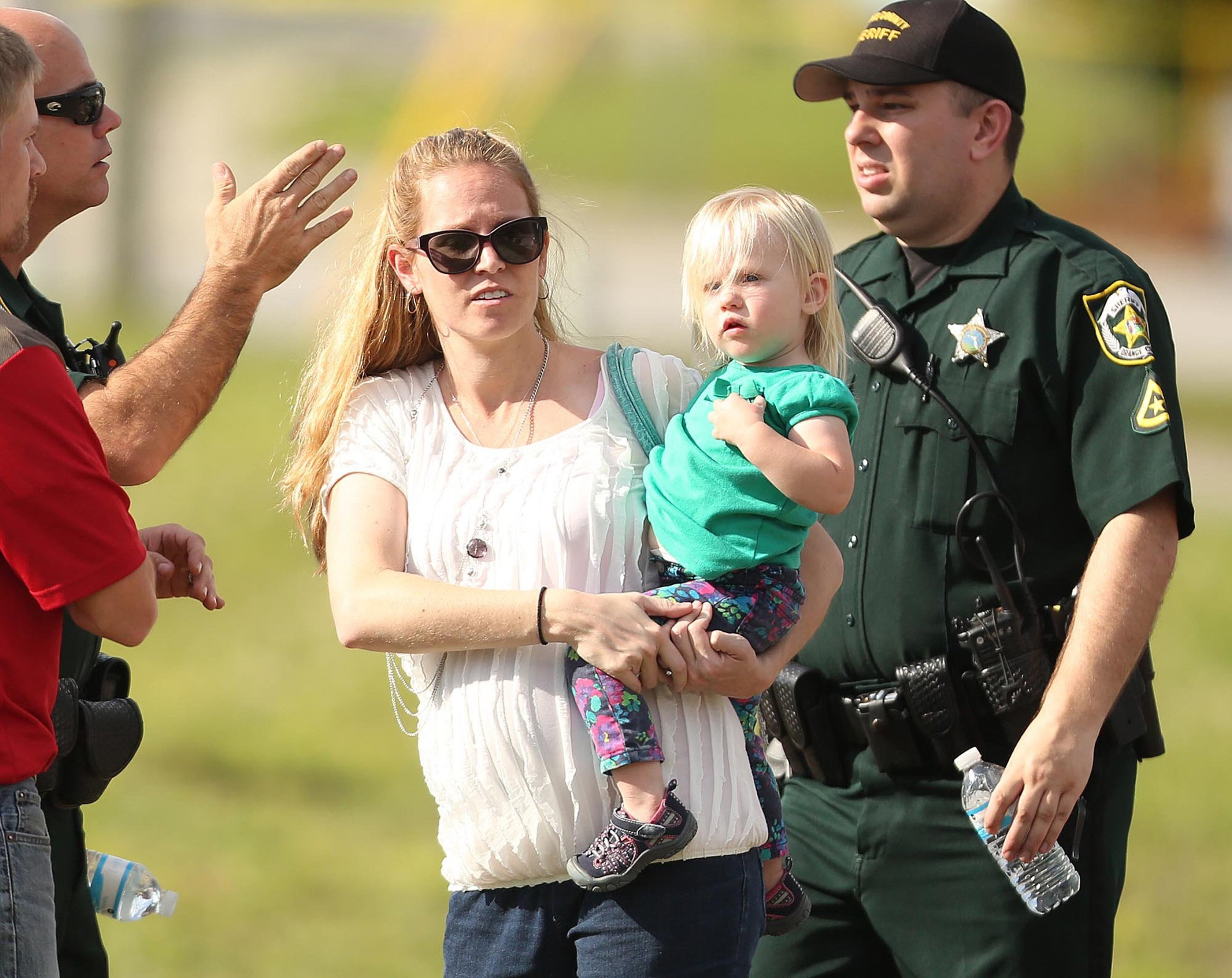 Children are escorted by their parents from the KinderCare Learning Center in Winter Park, Fla. (Stephen M. Dowell, Orlando Sentinel/MCT)