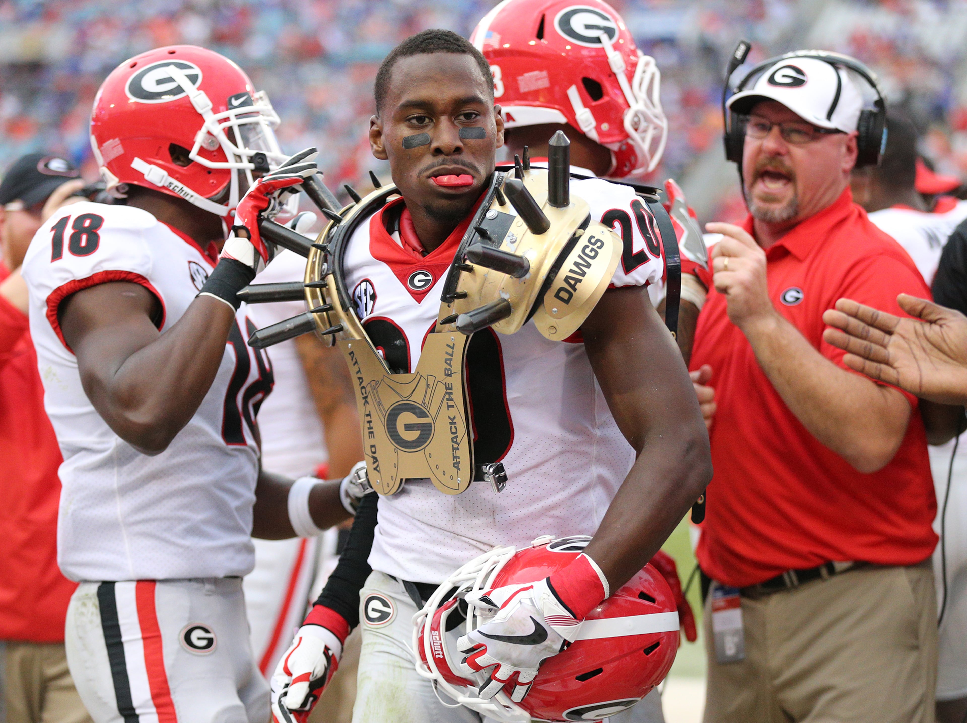 October 28, 2017 Jacksonville: After Georgia defensive back Tyrique McGhee sacked Florida quarterback Feleipe Franks forcing the fumble, J.R. Reed scooped it up and returned it for the score for a 35-0 lead and celebrated with the spikes on the sideline during the third quarter in the Georgia-Florida NCAA college football game on Friday, October 27, 2017, in Jacksonville. Georgia beat Florida 42-7. Curtis Compton/ccompton@ajc.com