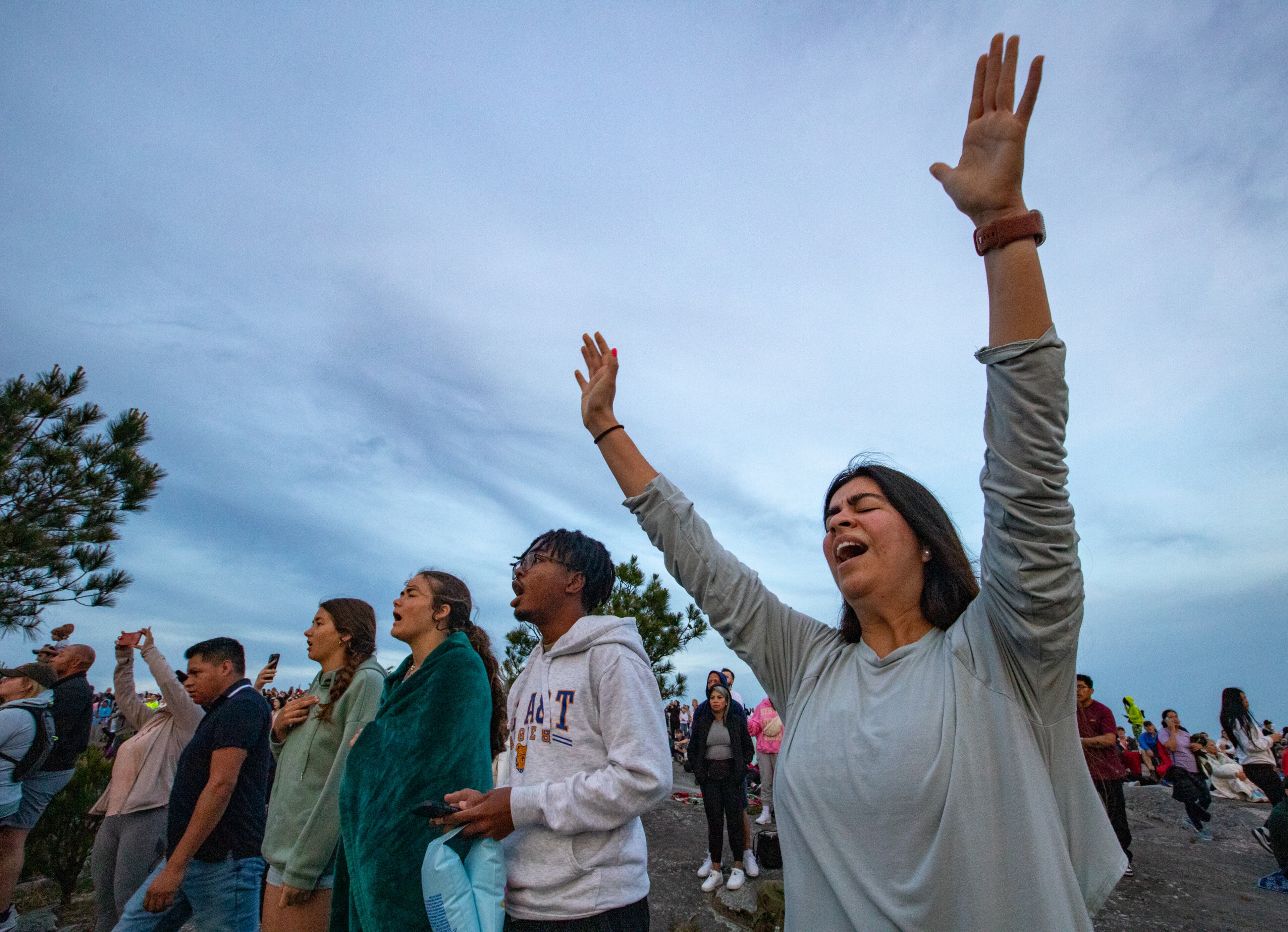 Thousands, including Gaby Bermudez of Atlanta, attend Easter sunrise service on top of Stone Mountain on Sunday, April 20, 2025. She was singing “How Great is Our God.” (Jenni Girtman for The Atlanta Journal-Constitution)