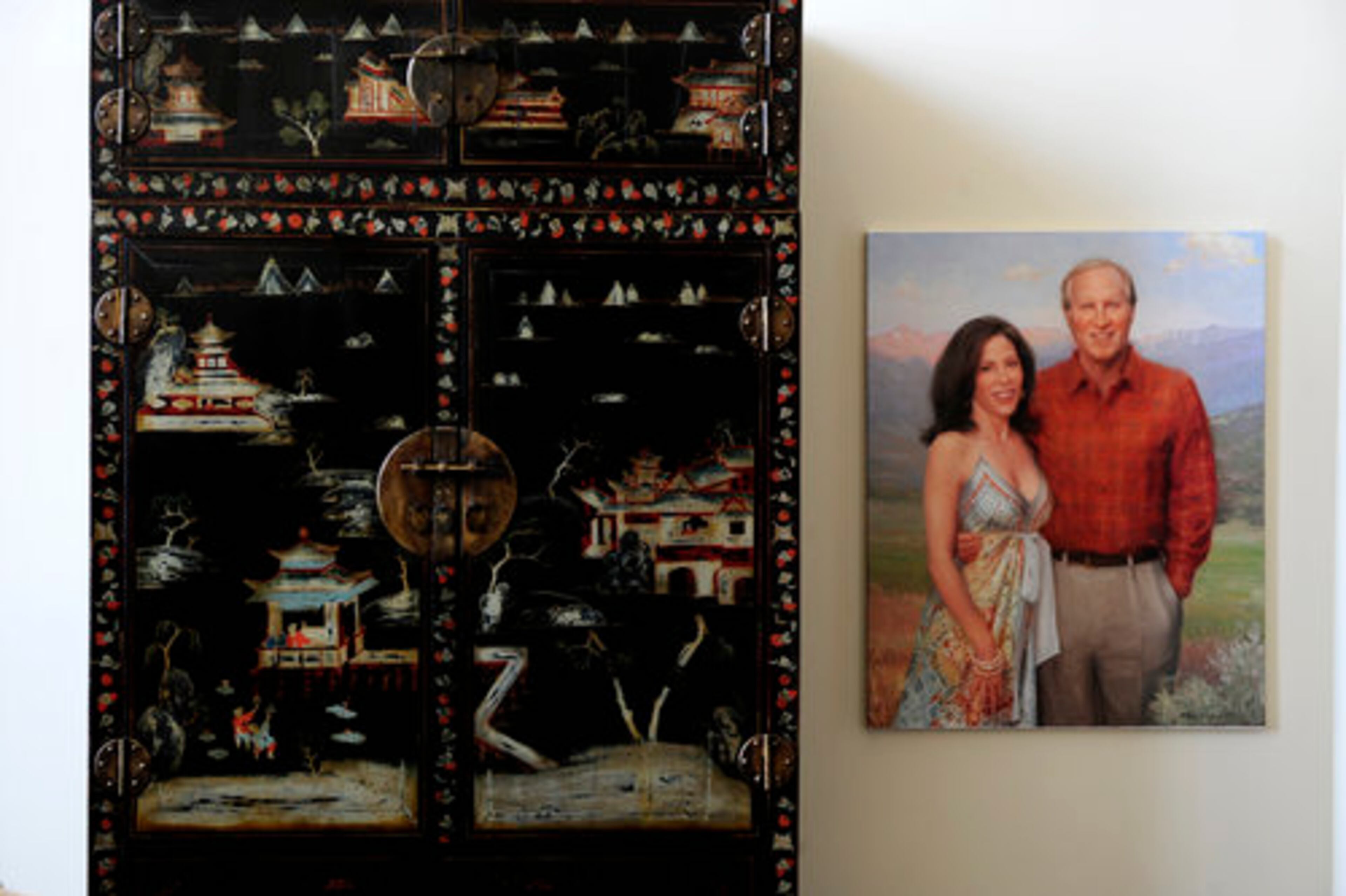 An antique Asian chest stands next to this casual portrait of Ron and Fran Terwilliger in the living room of the penthouse at Ovation.