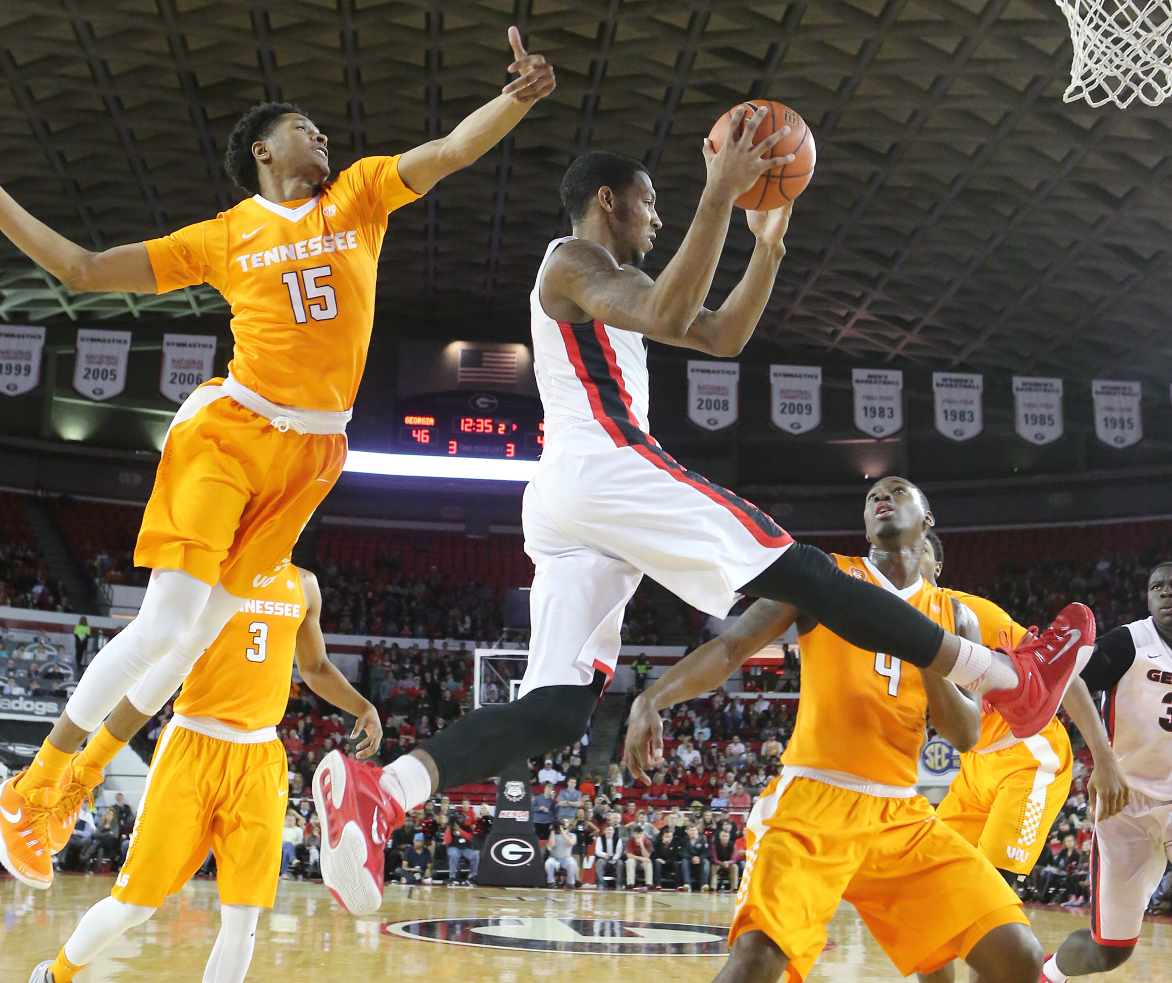 Georgia guard Charles Mann gets a pass off between Tennessee defenders Detrick Mostella (left) and Armani Moore in a basketball game on Wednesday, Jan. 13, 2016, in Athens. Georgia beat Tennessee 81-72. Curtis Compton / ccompton@ajc.com