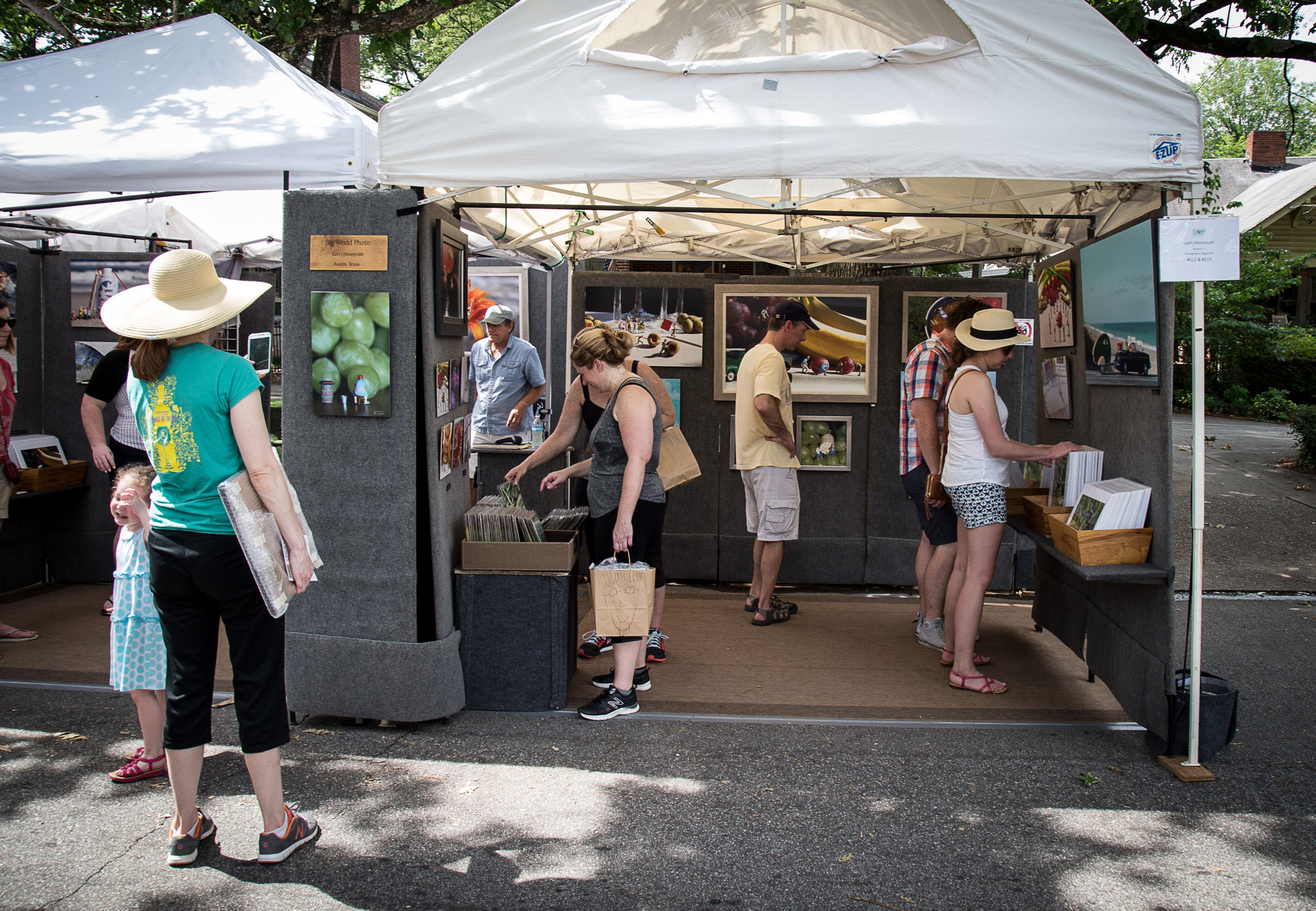 Shoppers look over the photographs of Lorri Honeycutt at the Summerfest in Atlanta on Saturday, June 4, 2016. STEVE SCHAEFER / SPECIAL TO THE AJC