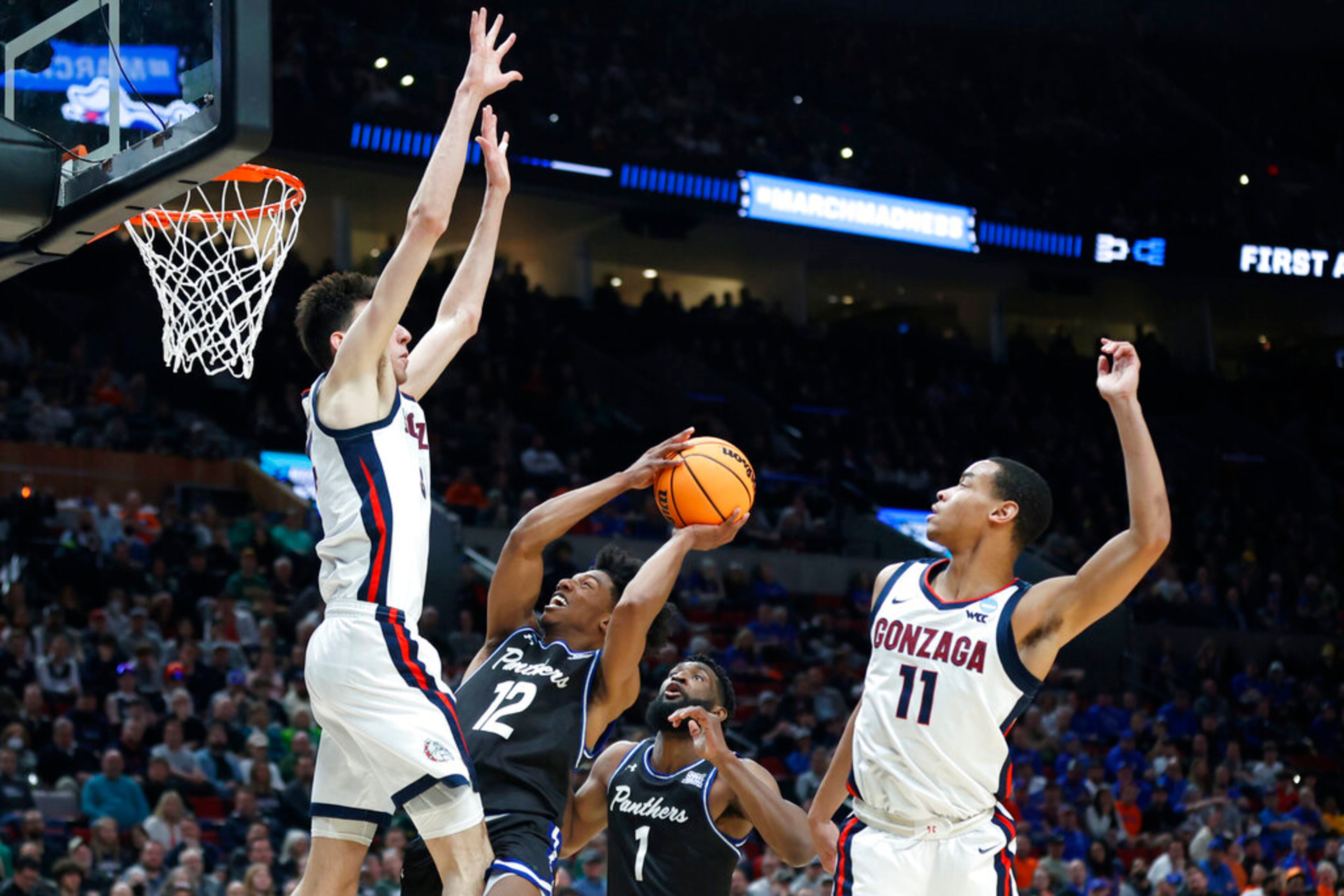 Georgia State guard Kane Williams (12) puts up a shot against Gonzaga center Chet Holmgren, left, and guard Nolan Hickman (11) during the first half of a first round NCAA college basketball tournament game, Thursday, March 17, 2022, in Portland, Ore. Gonzaga won 93-72. (AP Photo/Craig Mitchelldyer)