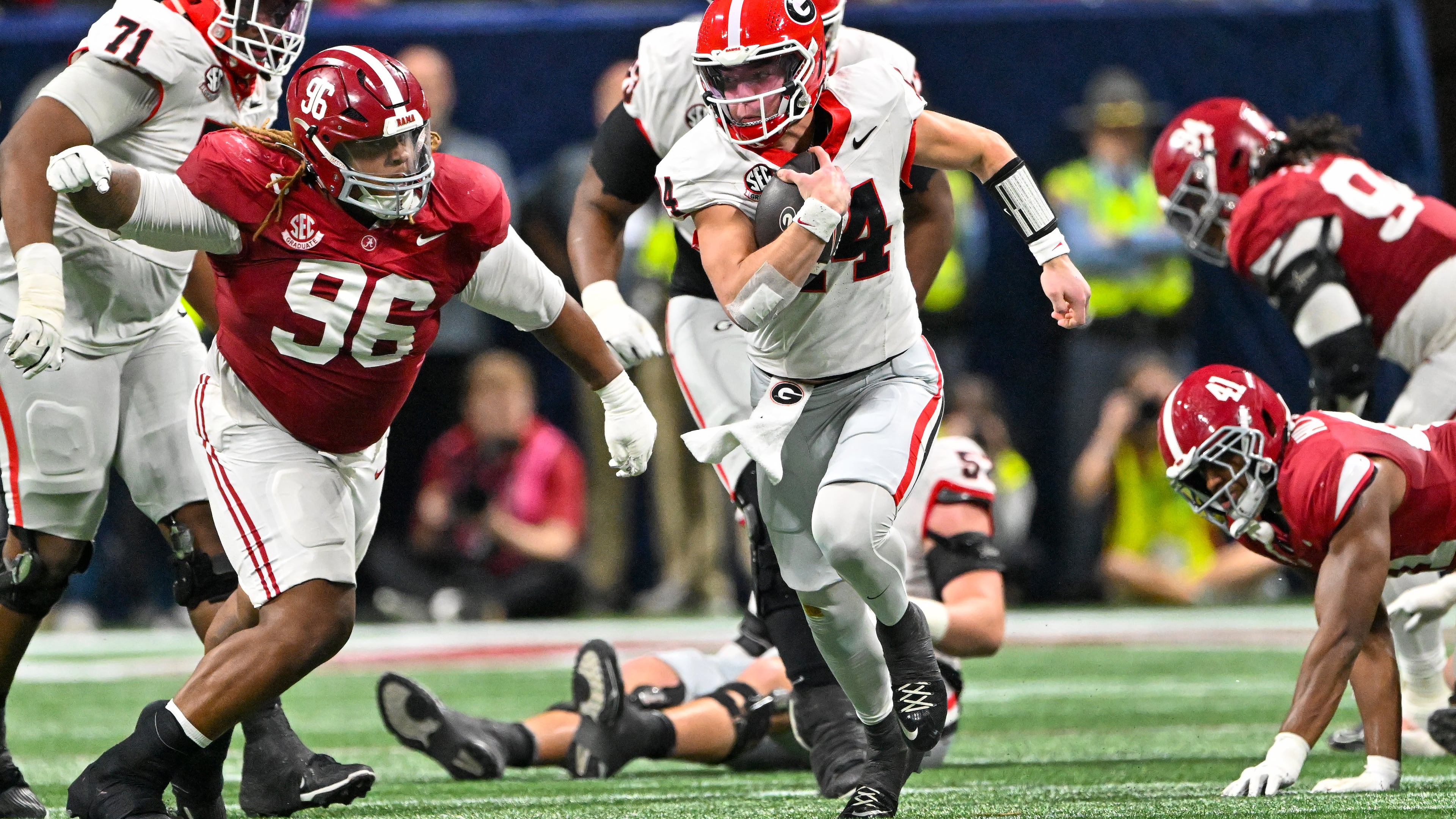 Georgia quarterback Gunner Stockton (14) runs a keeper play against Alabama defensive lineman Tim Keenan III (96) during the third quarter of the SEC Championship game at Mercedes-Benz Stadium, Saturday, Dec. 6, 2025, in Atlanta. (Hyosub Shin / AJC)