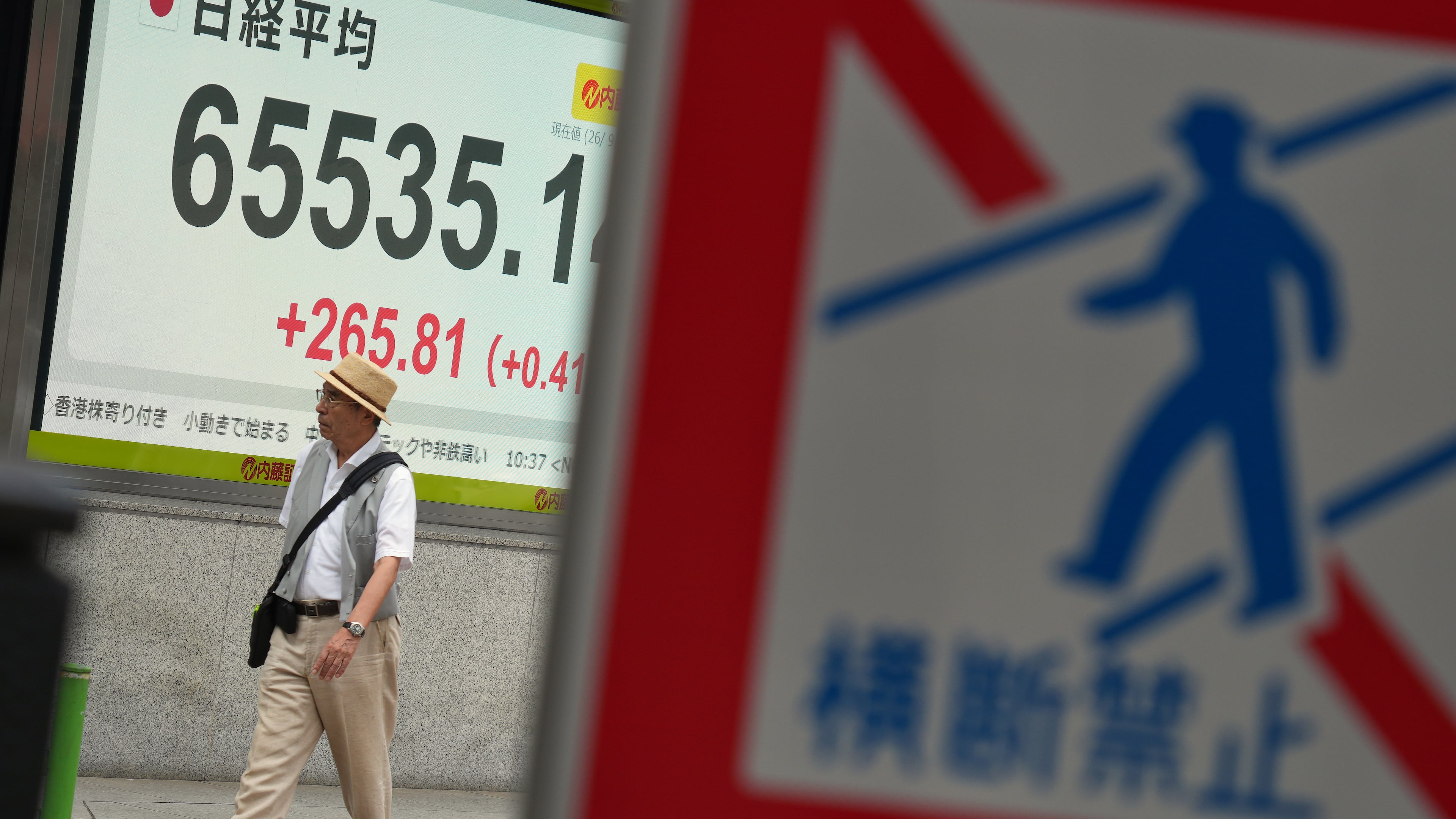 A person walks in front of an electronic stock board showing Japan's Nikkei index at a securities firm Wednesday, Sept. 9, 2026, in Tokyo. (AP Photo/Eugene Hoshiko)